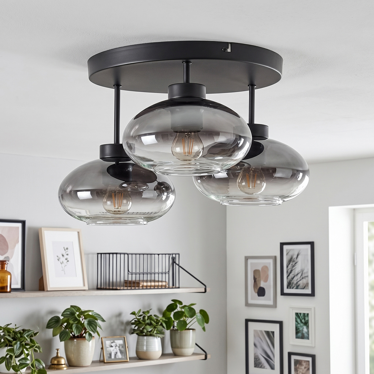 Schwarzer Deckenventilator mit drei rauchglasartigen Lampenschirmen und sichtbaren Glühbirnen.