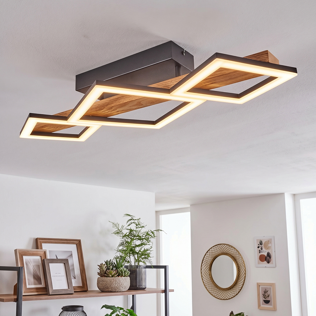 Moderne Deckenleuchte aus Holz und Metall, beleuchtet durch geometrische Quadrate.