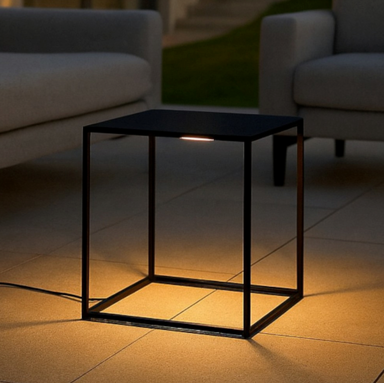 Un tavolo nero con illuminazione integrata si trova su un patio.