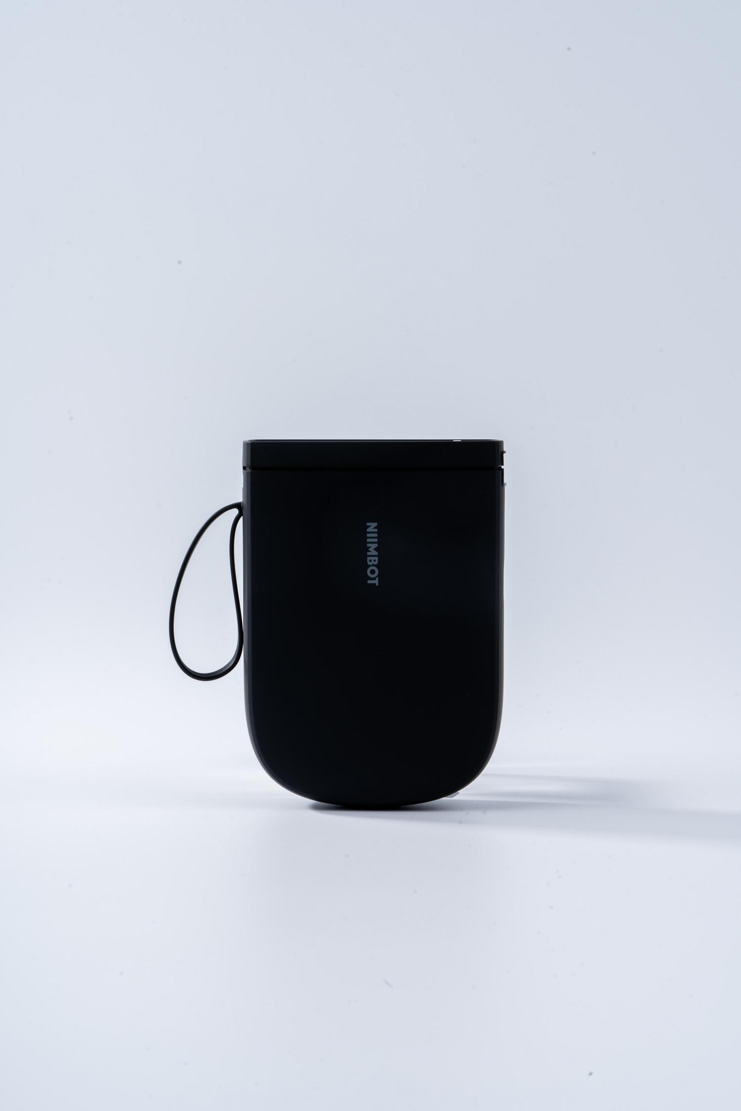 Un dispositivo nero con cinturino, su sfondo bianco.
