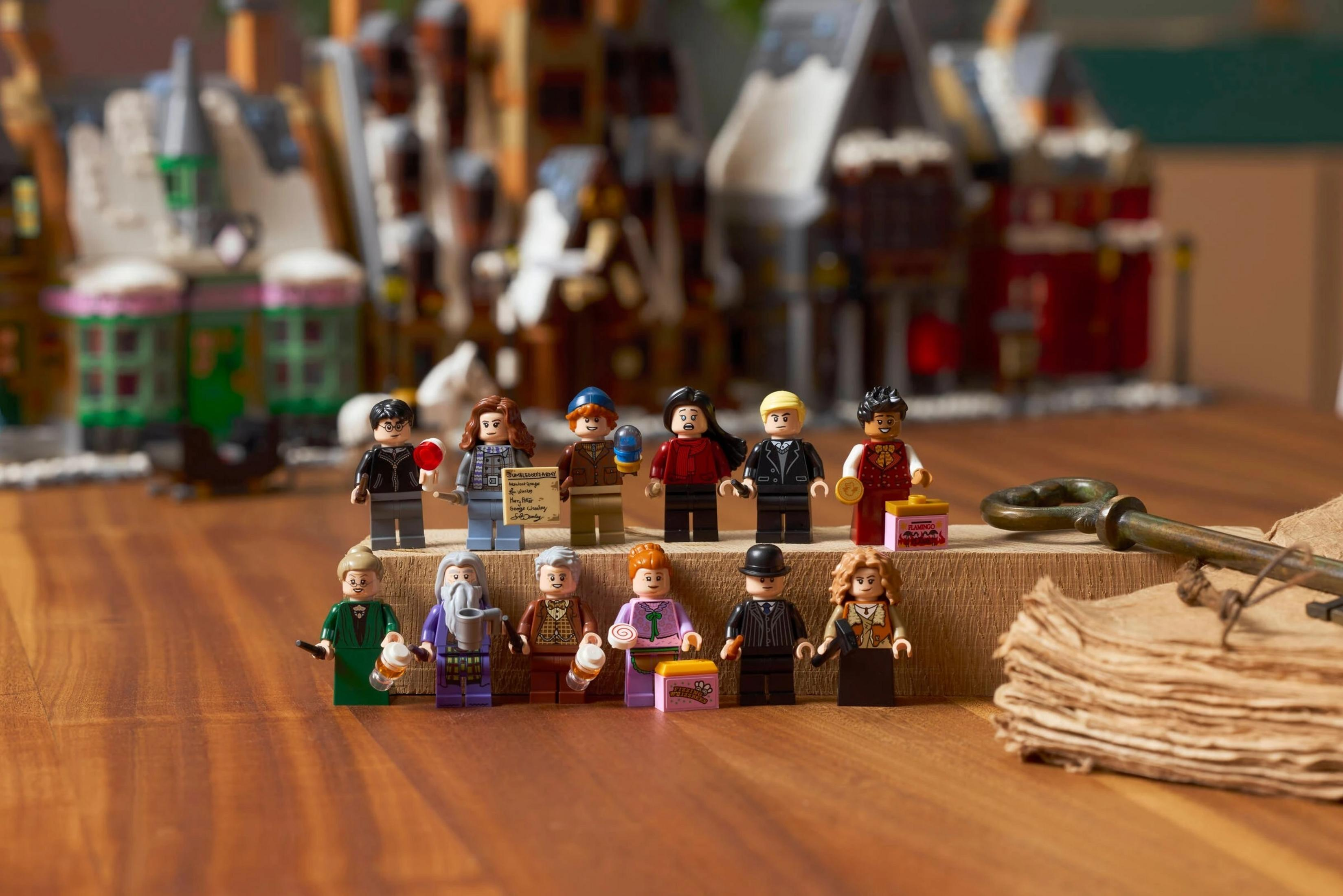 Figuras de Lego posan ante un telón de fondo de edificios de Hogwarts con una llave y libros.