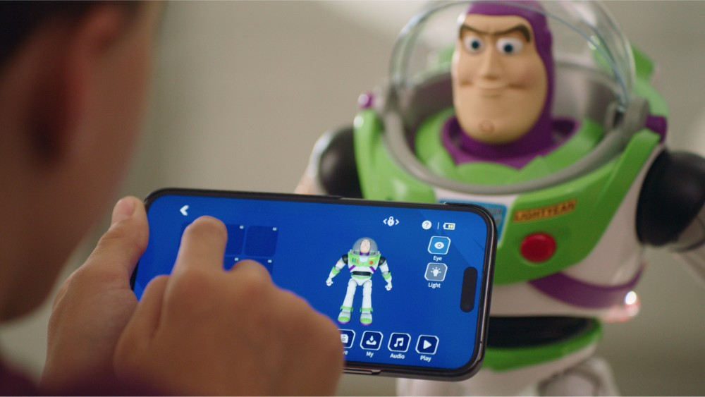 Un niño usa un smartphone para controlar un robot de juguete Buzz Lightyear.
