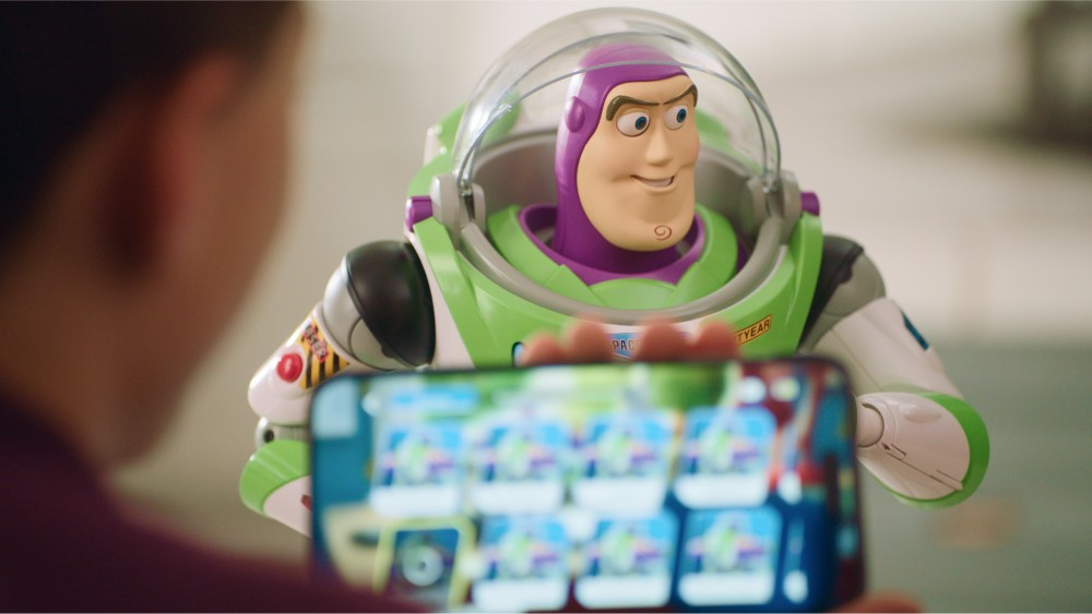 Un juguete de Buzz Lightyear se muestra en la pantalla de un teléfono mostrando una app con muchos iconos.