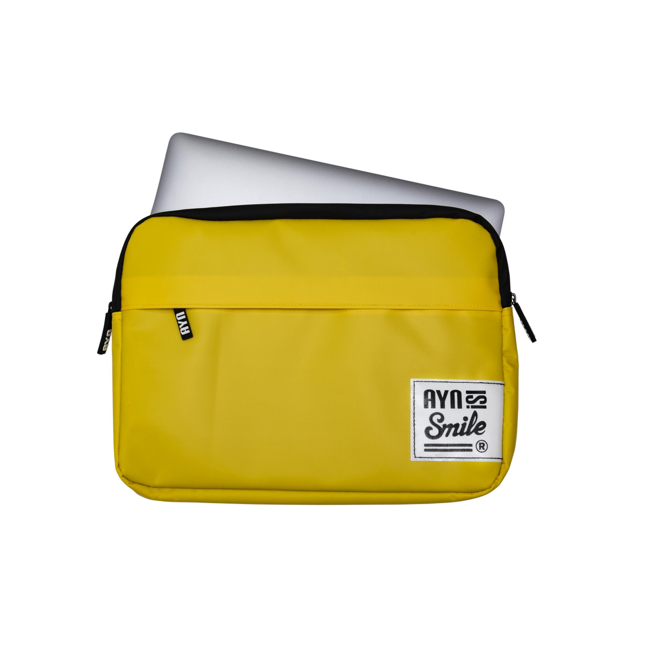 Una funda amarilla para portátil con un portátil plateado asomando por arriba.