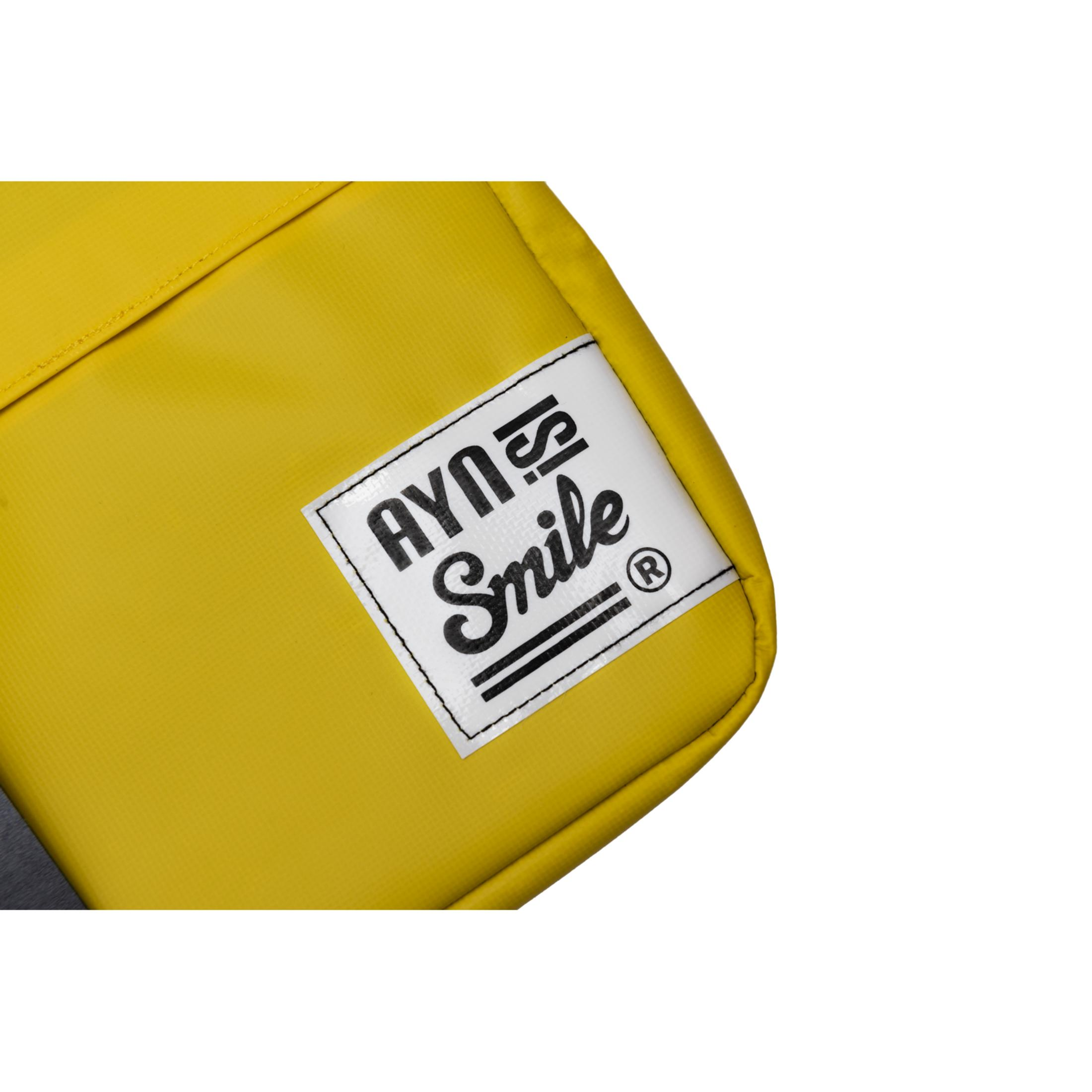 Una bolsa amarilla con una etiqueta blanca que dice "AYNS Smile".