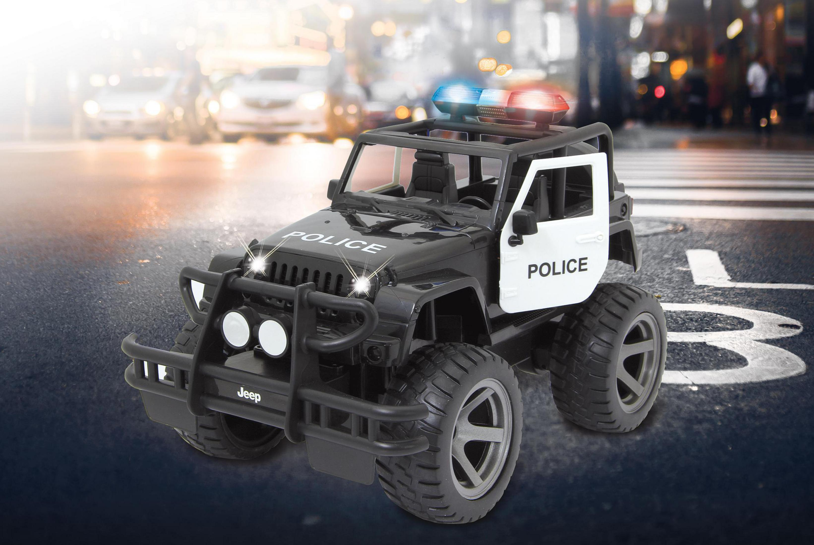 Ein Spielzeug-Polizeiauto mit Blaulicht auf nasser Straße mit Autos im Hintergrund.