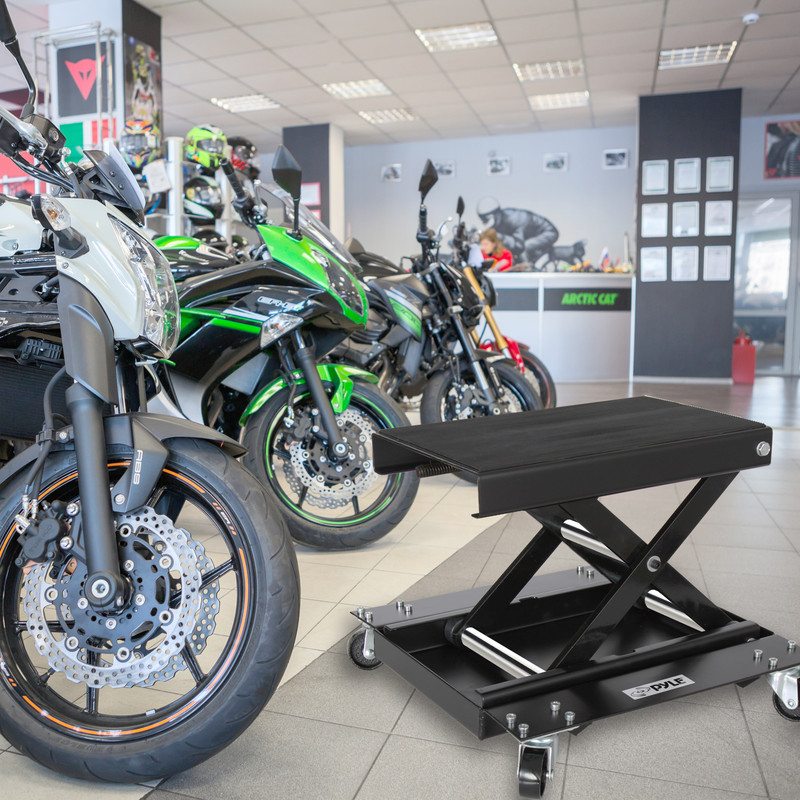 Ein schwarzer Motorradheber steht im Vordergrund, im Hintergrund sind Motorräder.