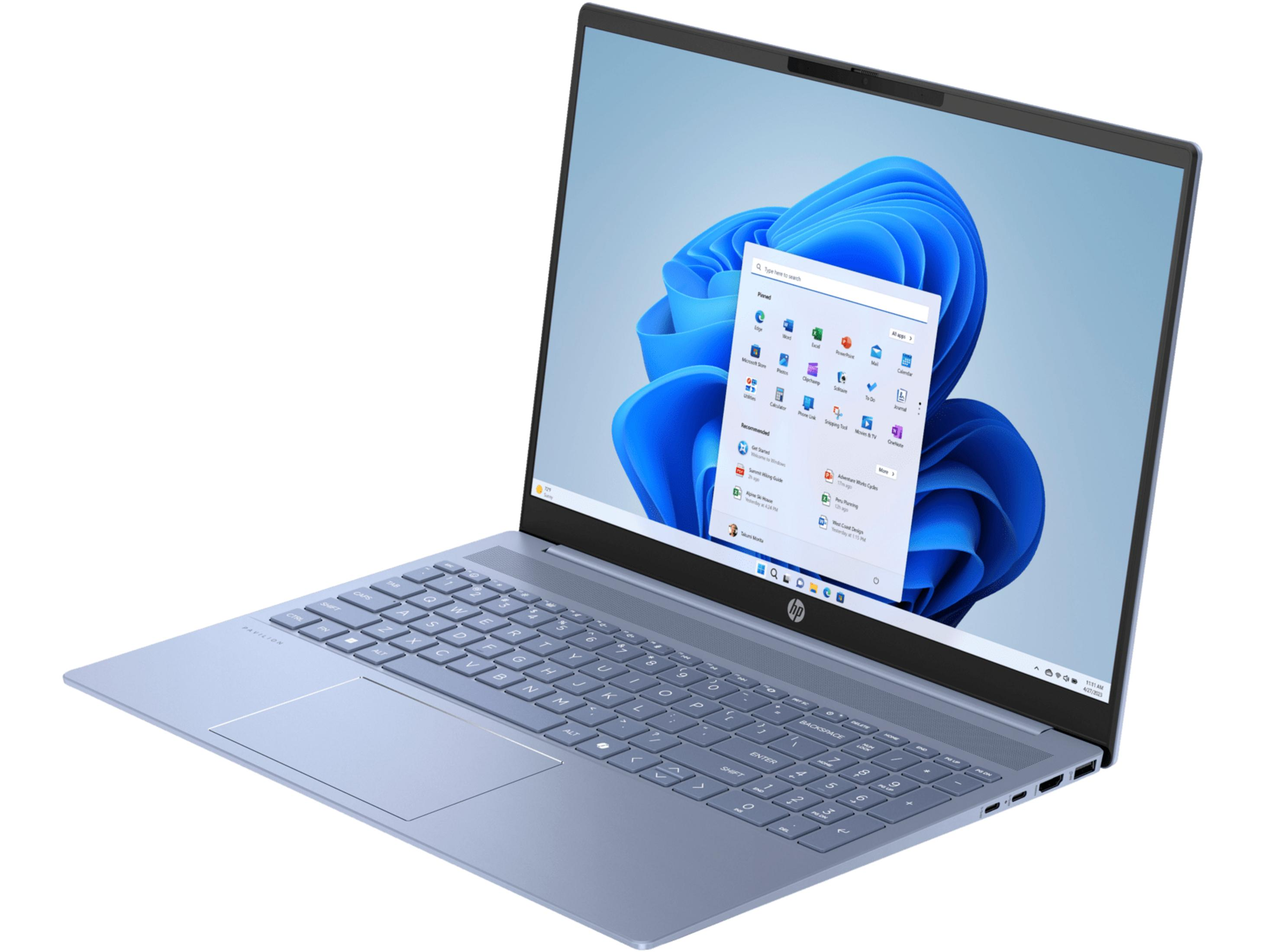 Un portátil azul claro muestra un menú de inicio abierto con el fondo de Windows 11.
