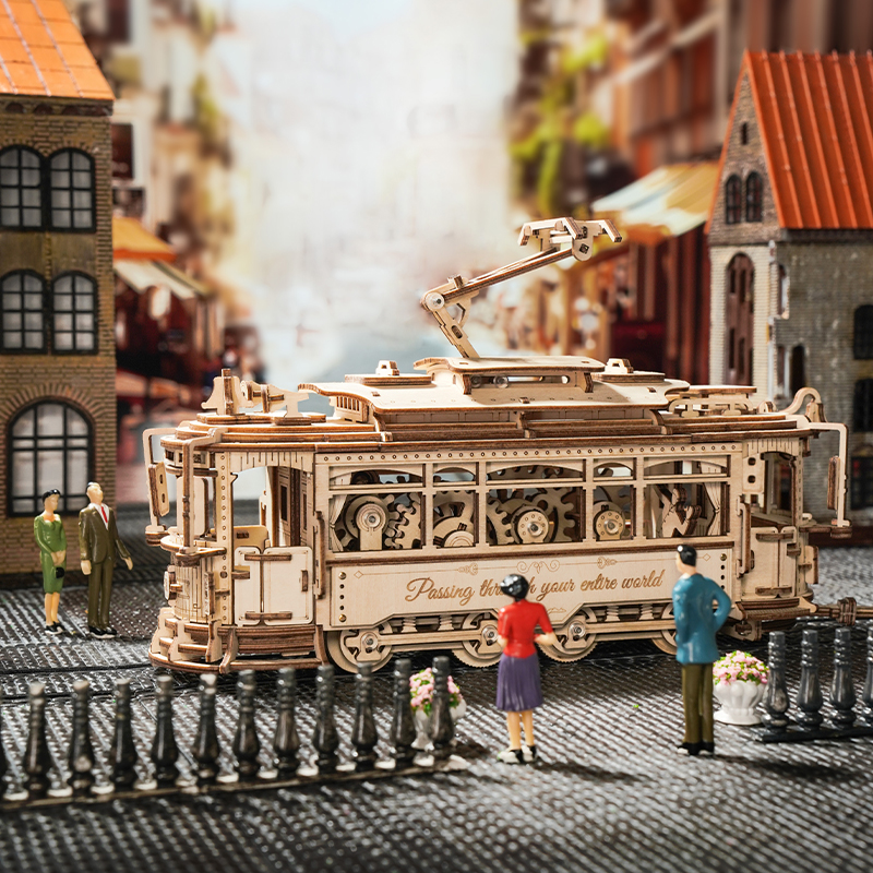 Ein Holzmodell einer Straßenbahn mit Zahnrädern und Figuren in einer Miniaturstadt.