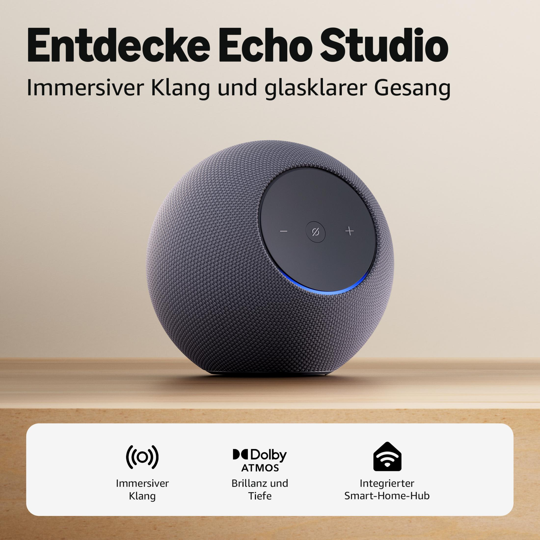 Un altavoz gris Echo Studio se sienta sobre una mesa de madera.