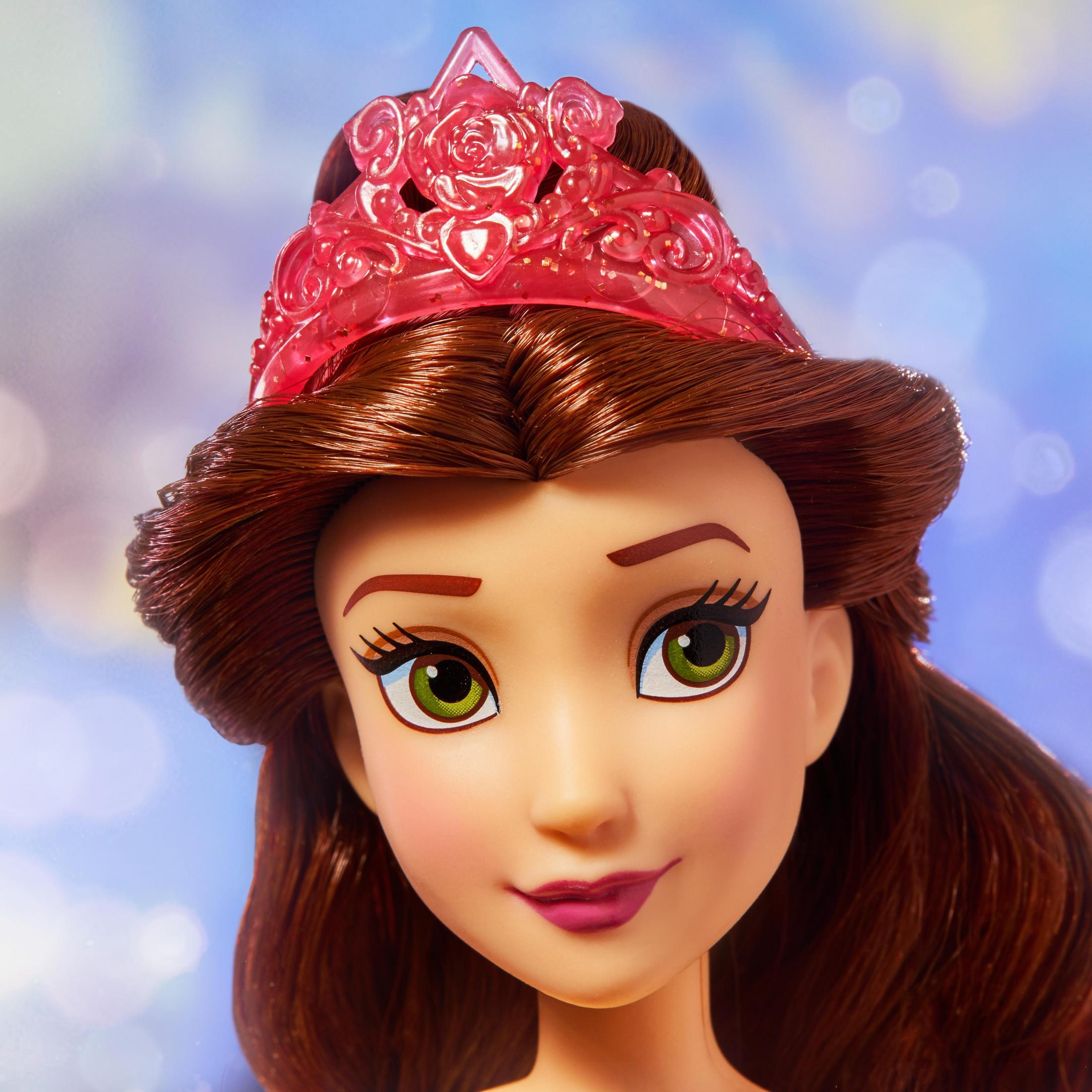 Bambola con capelli castani e tiara, ritratto ravvicinato, su sfondo sfocato.