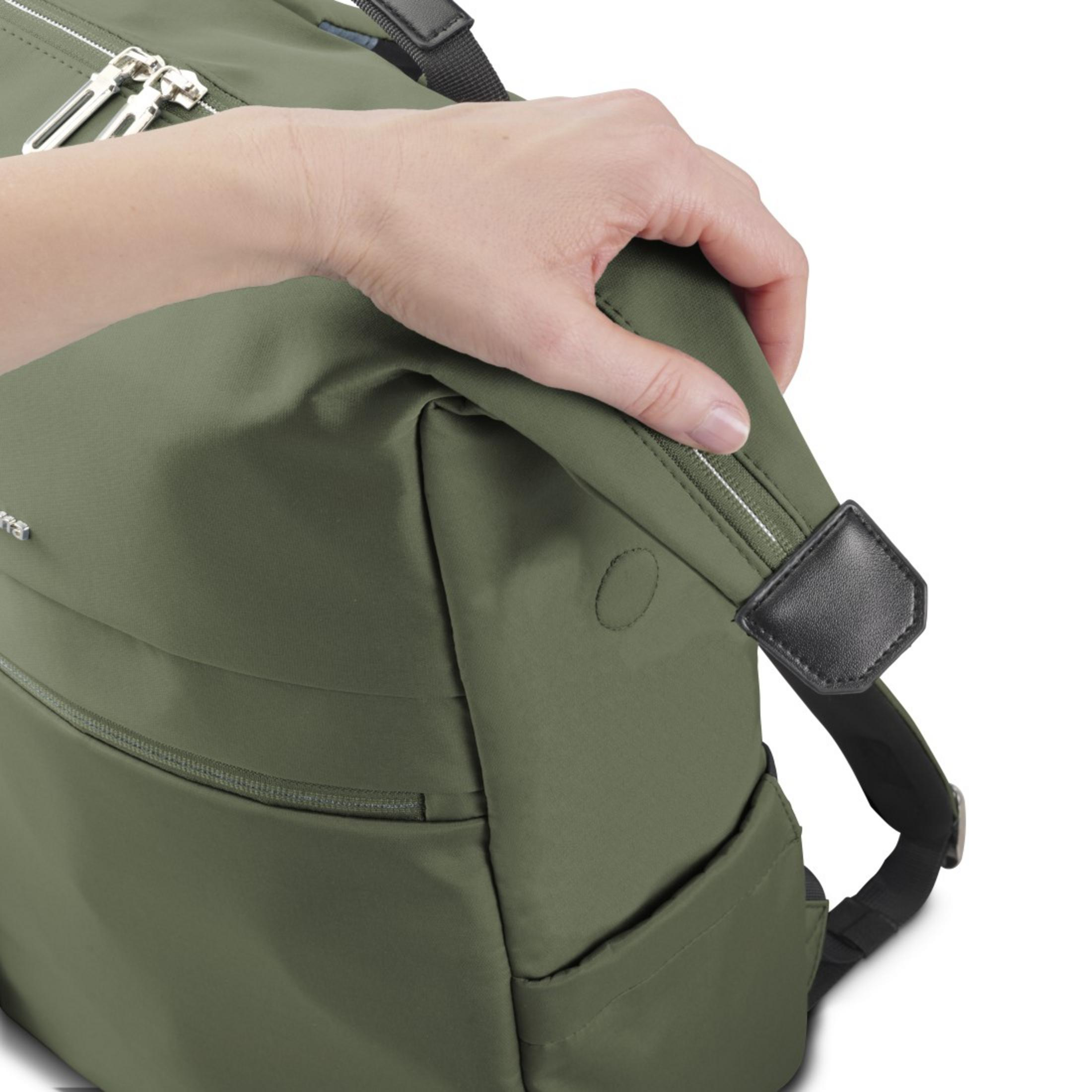 Una mano afferra il cinturino della borsa verde oliva vicino a un dettaglio in pelle nera.