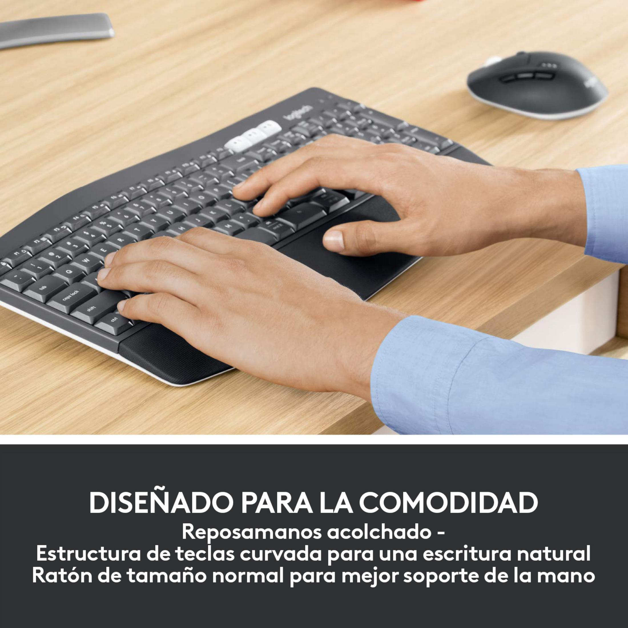 Mani su una tastiera e un mouse Logitech su una scrivania di legno.