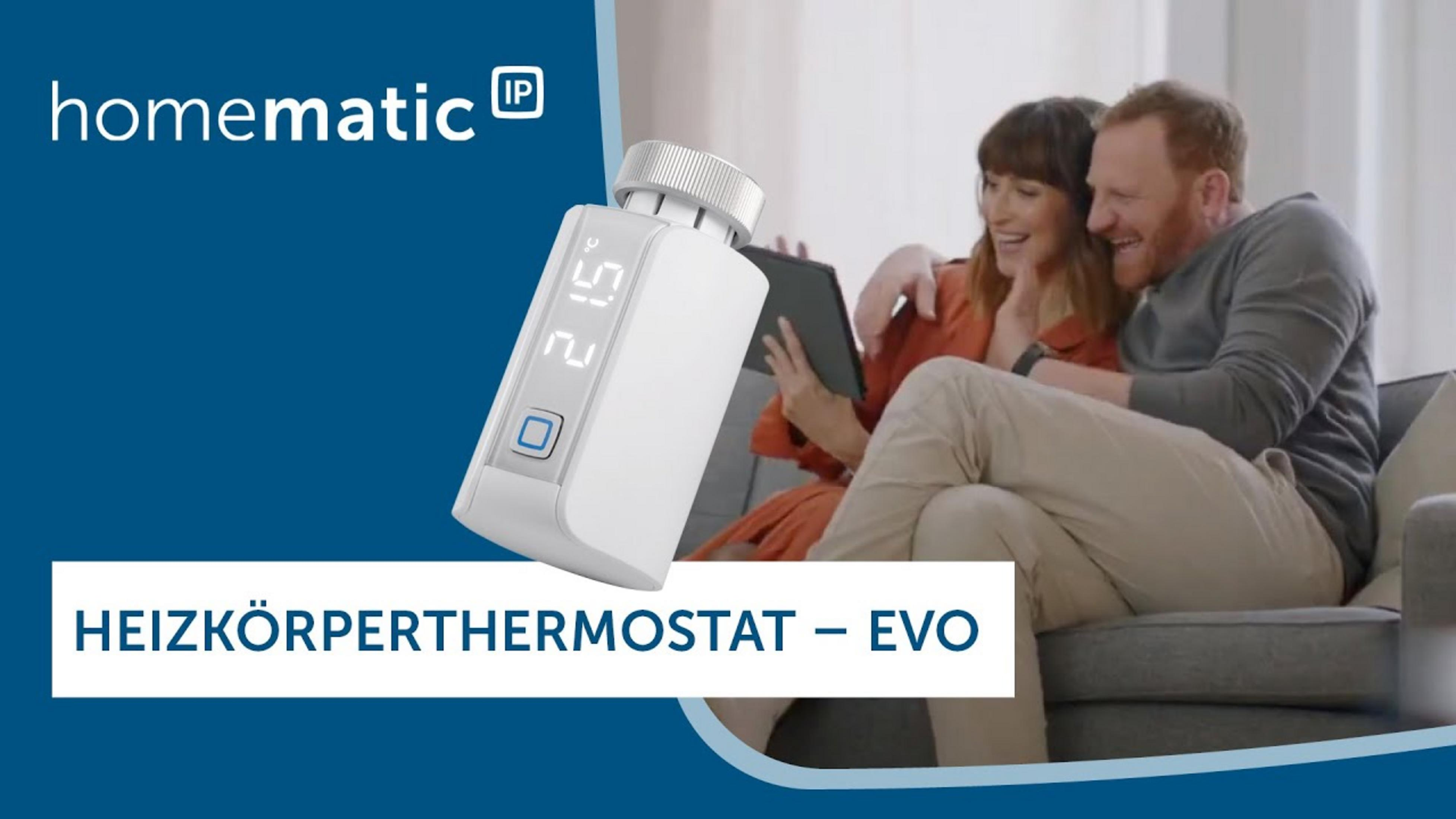 Ein Mann und eine Frau auf einem Sofa blicken auf ein Tablet. Ein Heizkörperthermostat ist im Vordergrund.