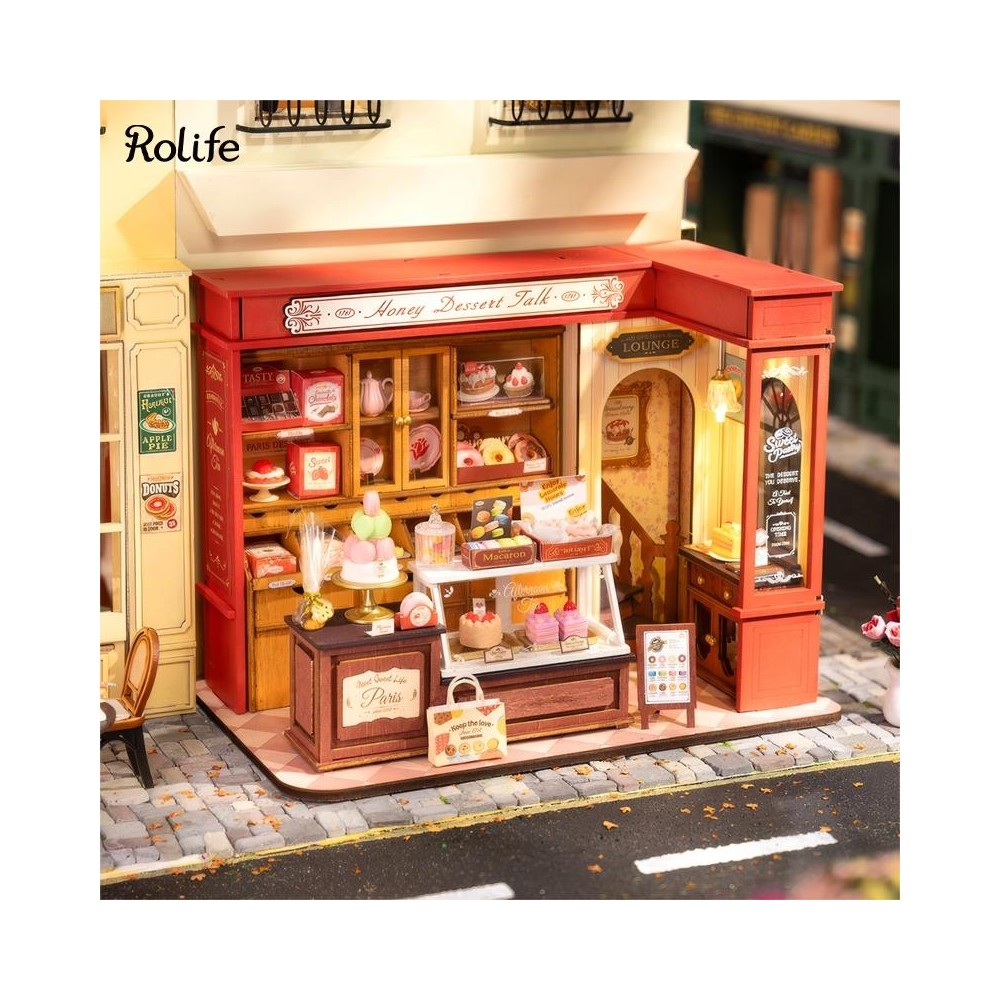 Negozio di dolci in miniatura con vetrine piene di torte, macaron e pasticcini.