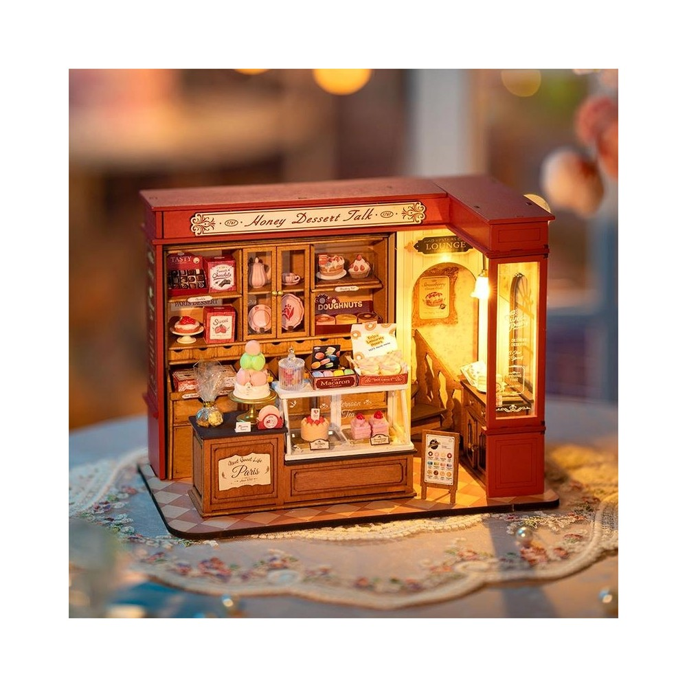 Negozio di dessert in miniatura con scaffali che espongono torte, macaron e ciambelle.