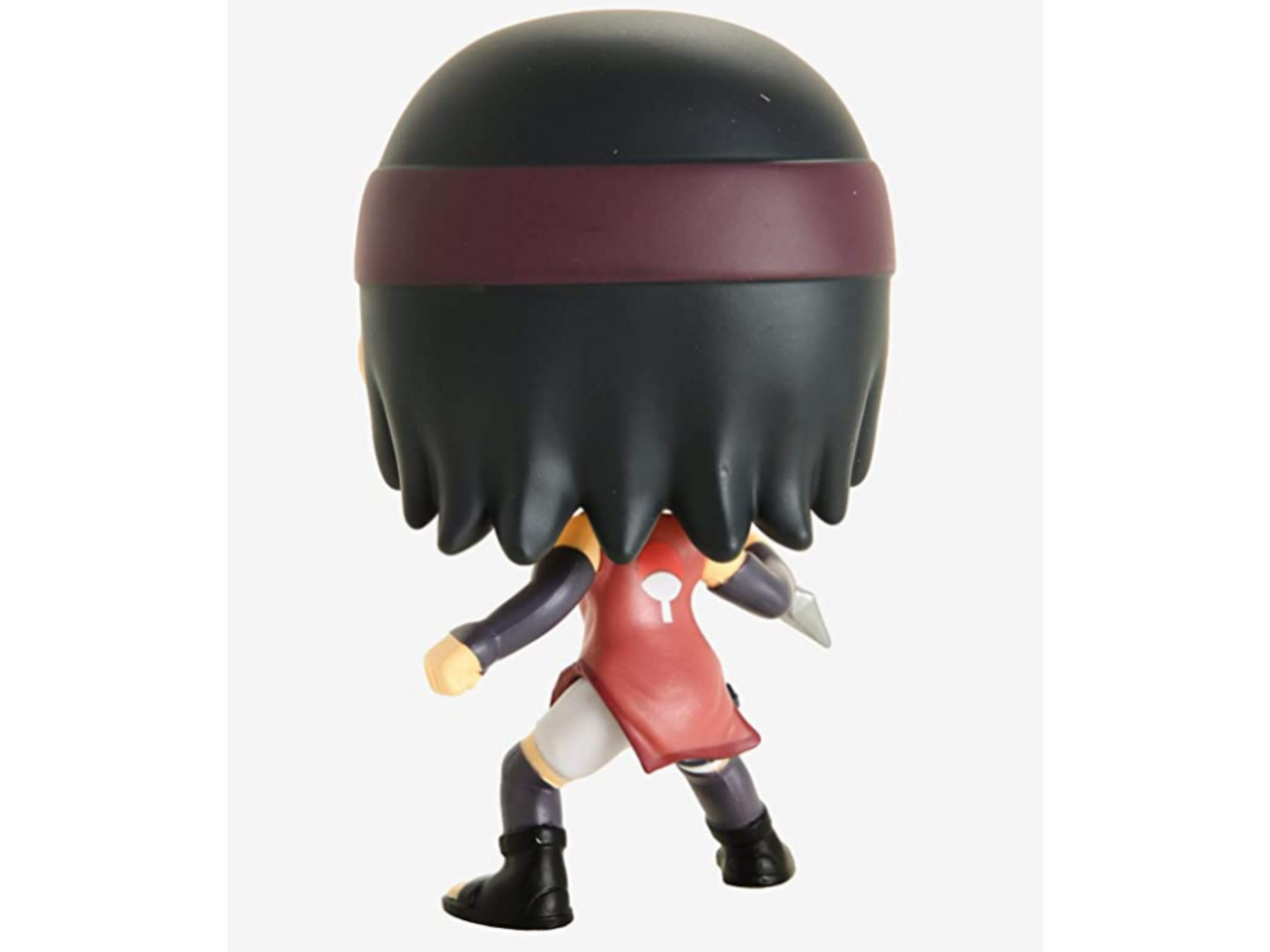 Figura vista de espaldas con pelo negro, cinta, top rojo y arma.
