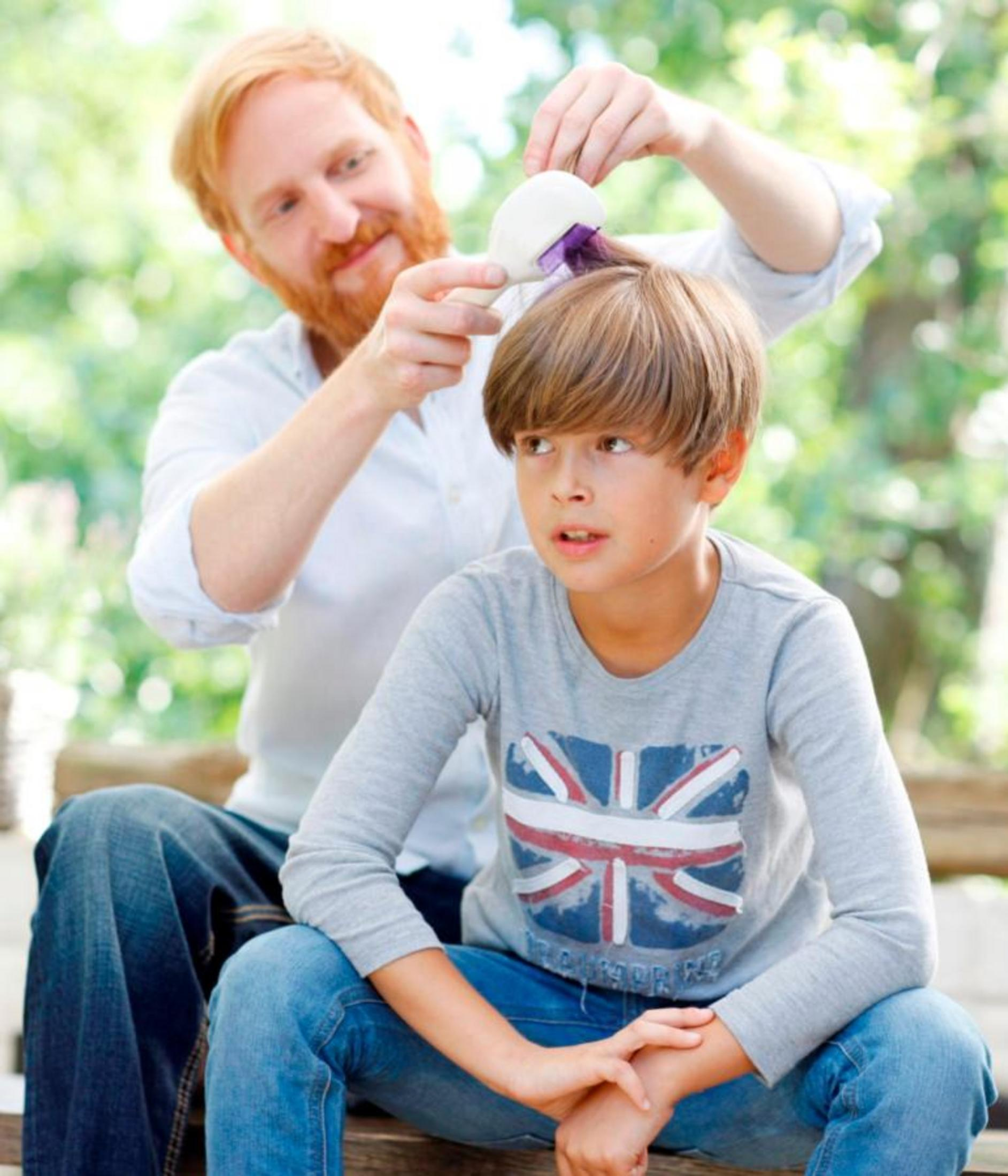 Un hombre con barba peina a un niño con camiseta Union Jack.