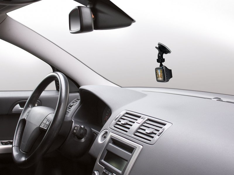 Armaturenbrett eines Autos mit Dashcam, Lenkrad und Lüftungsschlitzen.