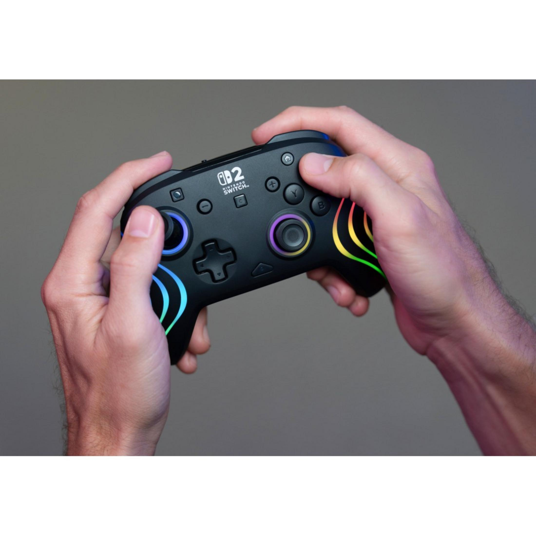 Mani che tengono un controller nero Nintendo Switch con luci colorate.