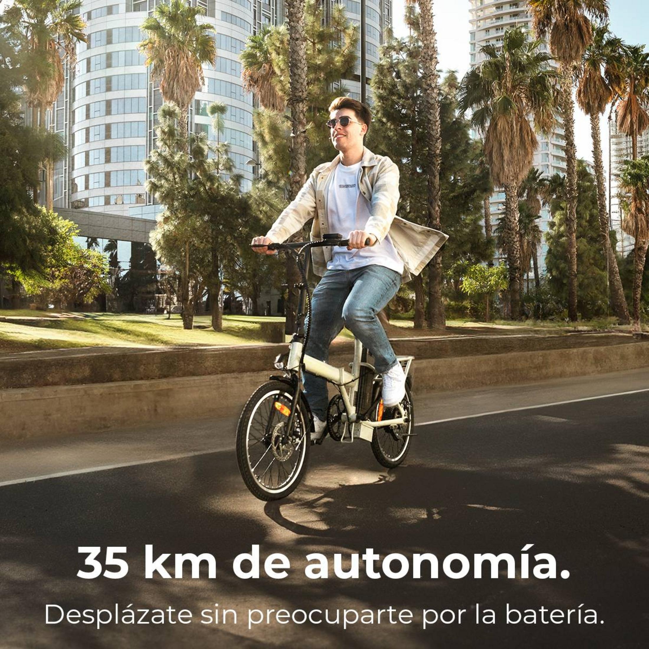Uomo in bicicletta con palme ed edifici sullo sfondo.