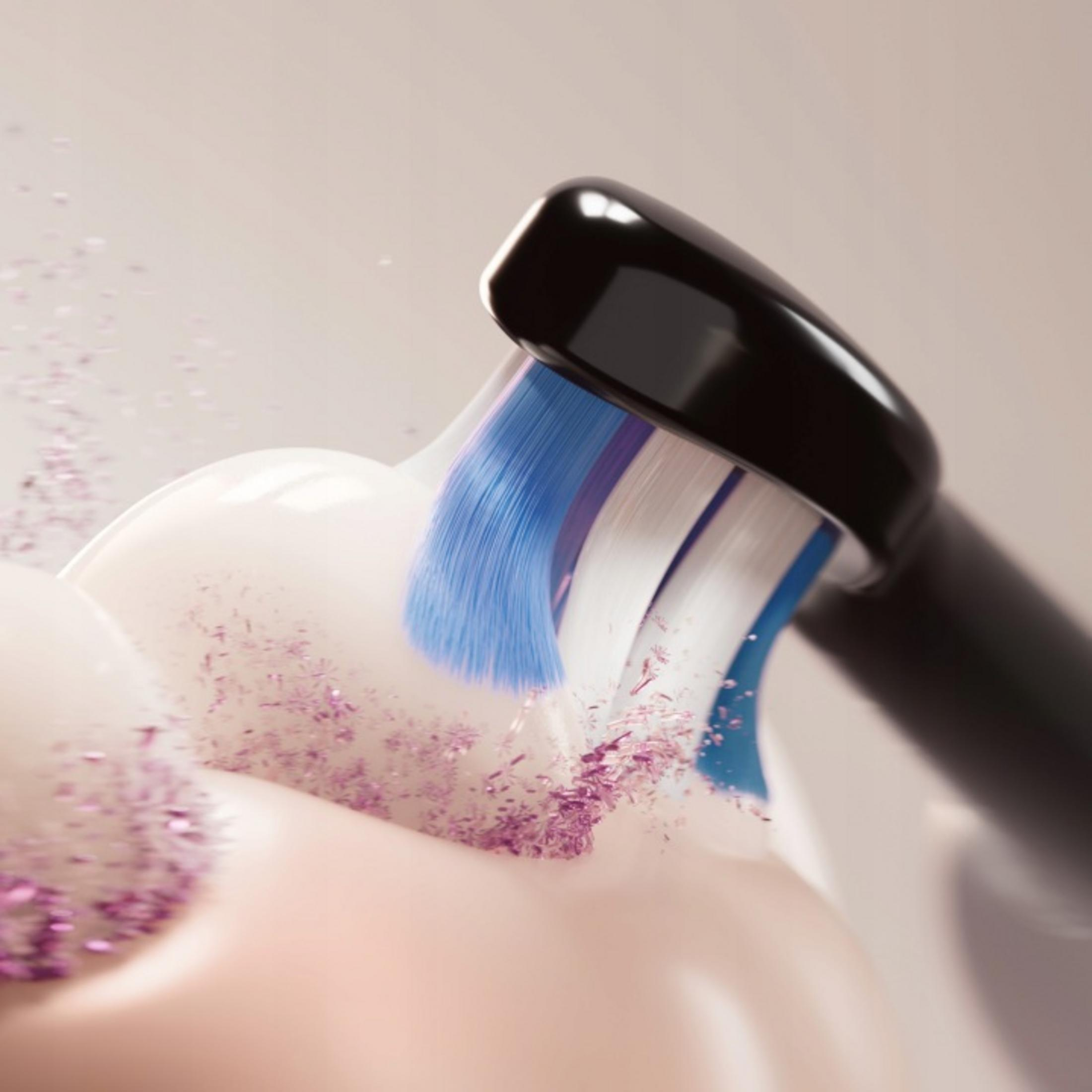 Spazzolino elettrico con setole blu pulisce denti bianchi con glitter viola.