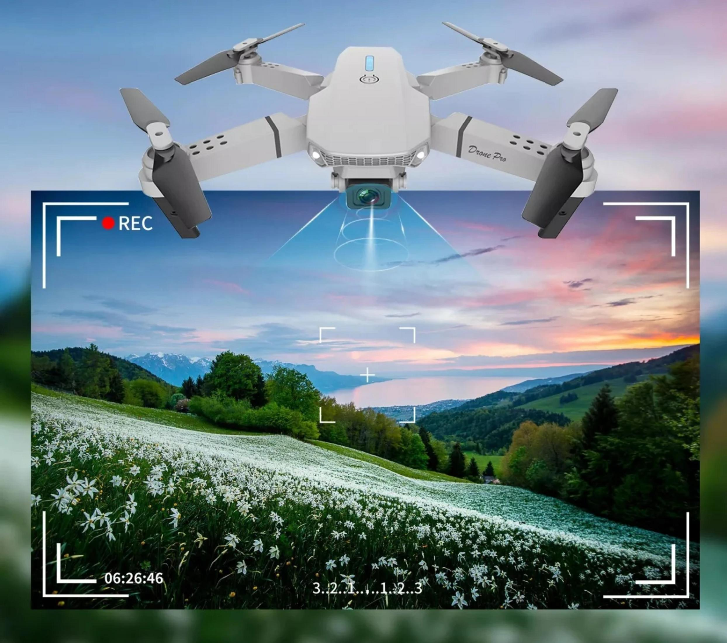 Un drone bianco vola su un prato fiorito e un lago.