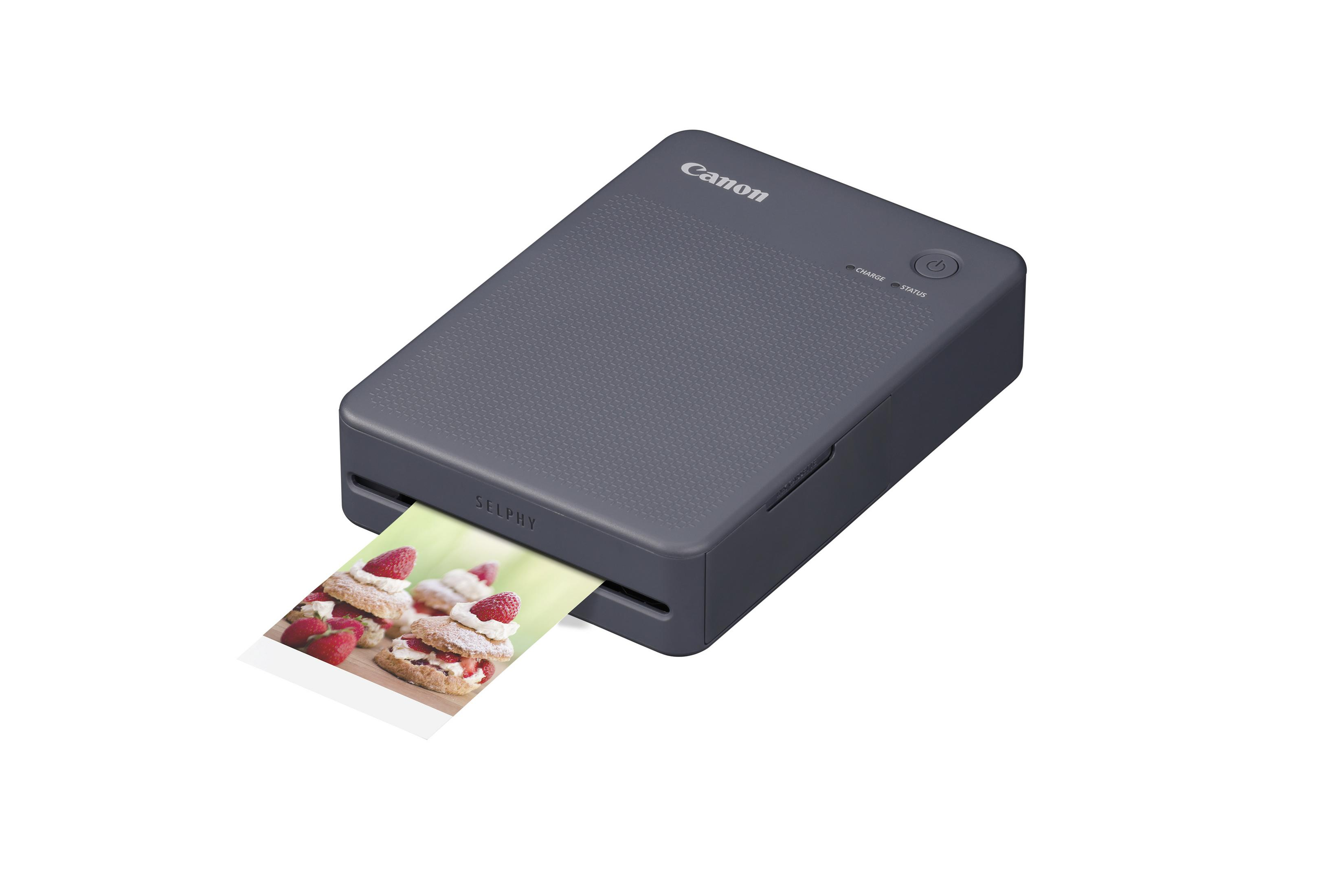 Ein grauer Canon Selphy Drucker druckt ein Bild von Erdbeerkuchen mit Sahne.