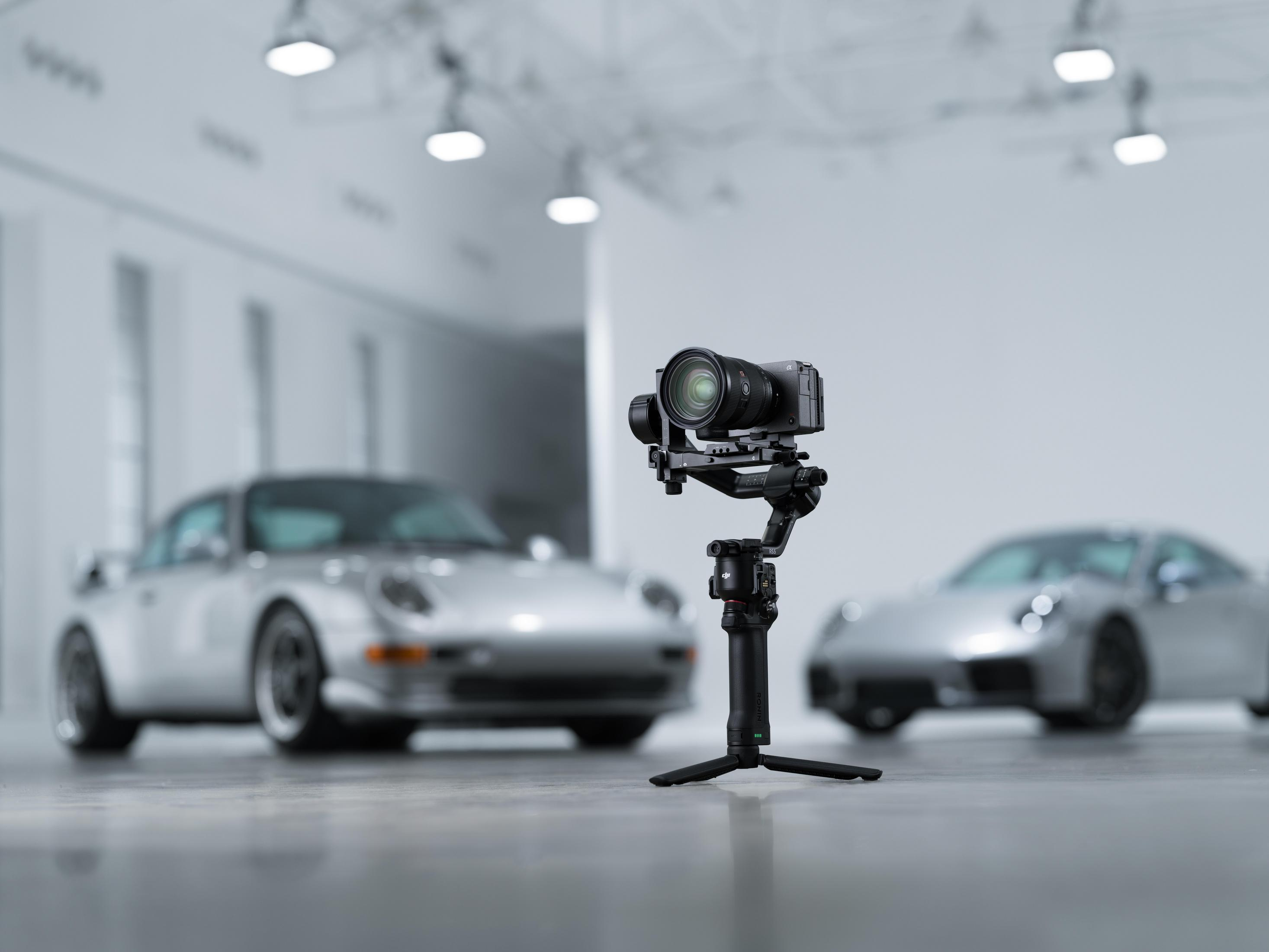 Telecamera su gimbal davanti ad auto sfocate in uno showroom.