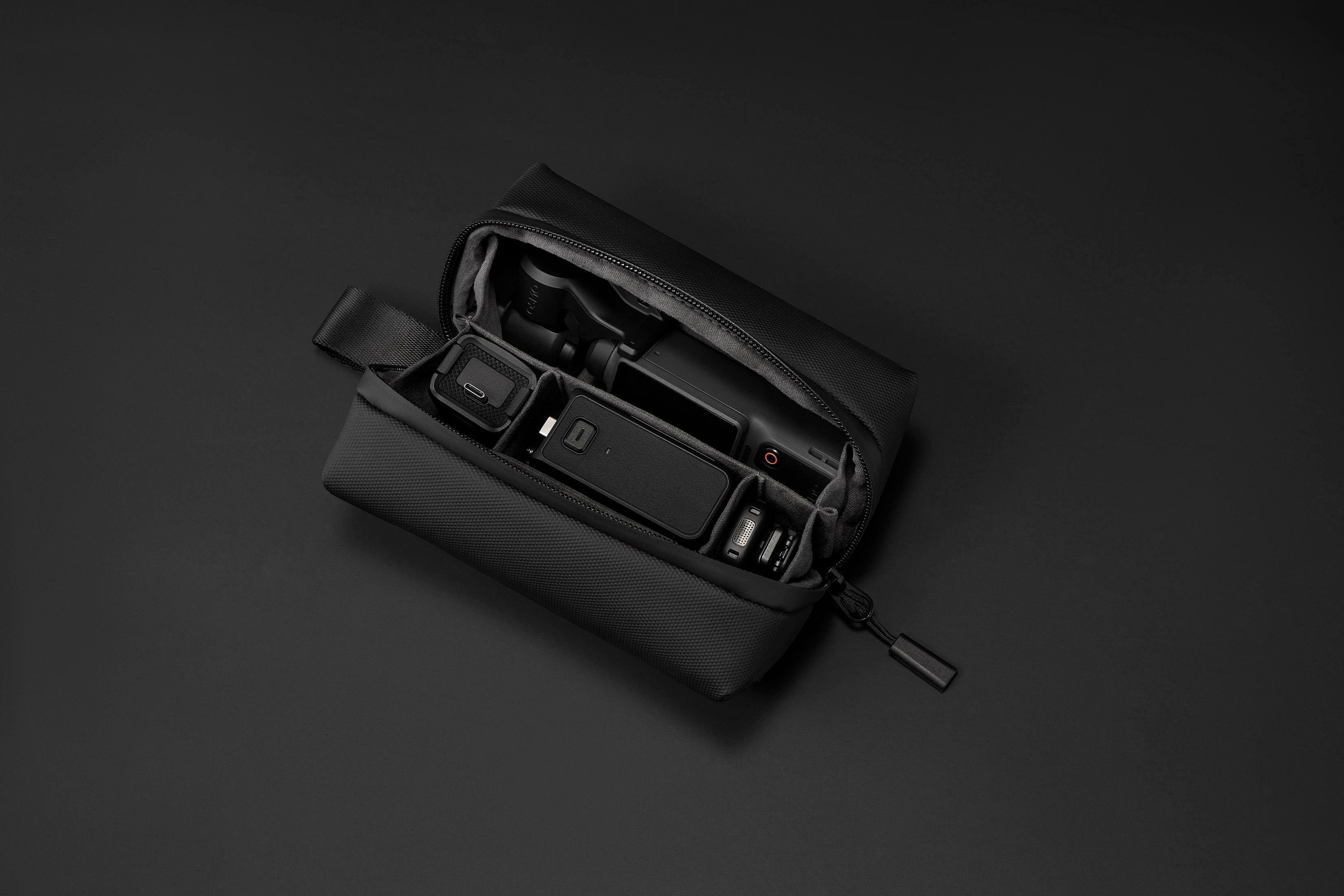 Bolsa negra con gimbal, batería, cables y cargador USB-C.