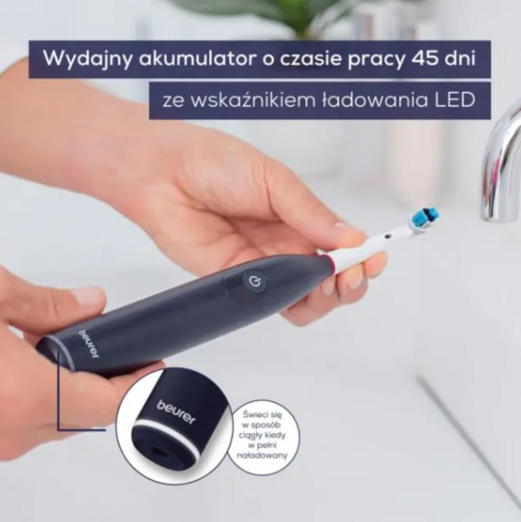 Eine Person hält eine dunkelblaue elektrische Zahnbürste mit blauem Bürstenkopf.