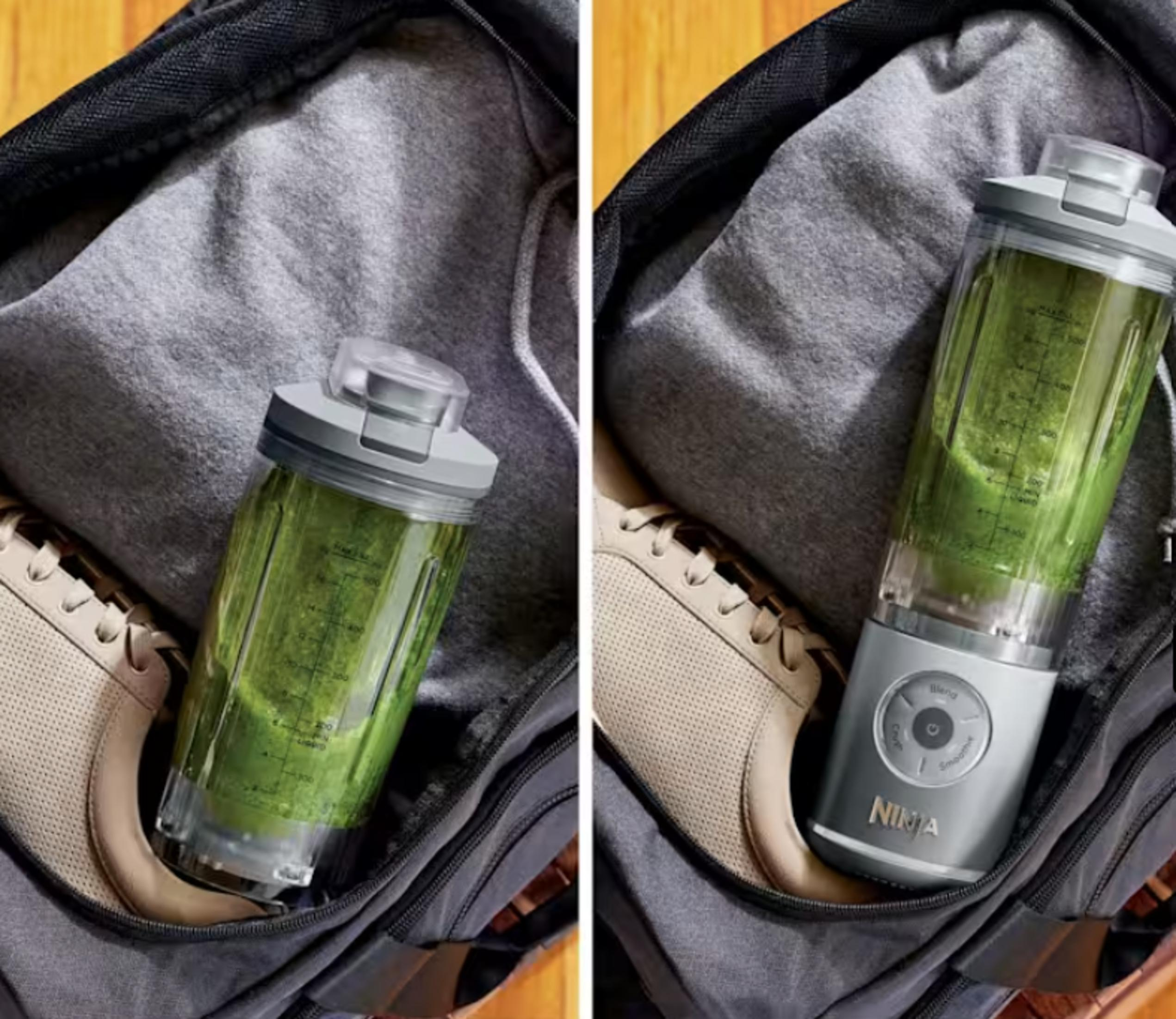 Un frullatore portatile con frullato verde in una borsa da palestra accanto a una felpa e scarpe.