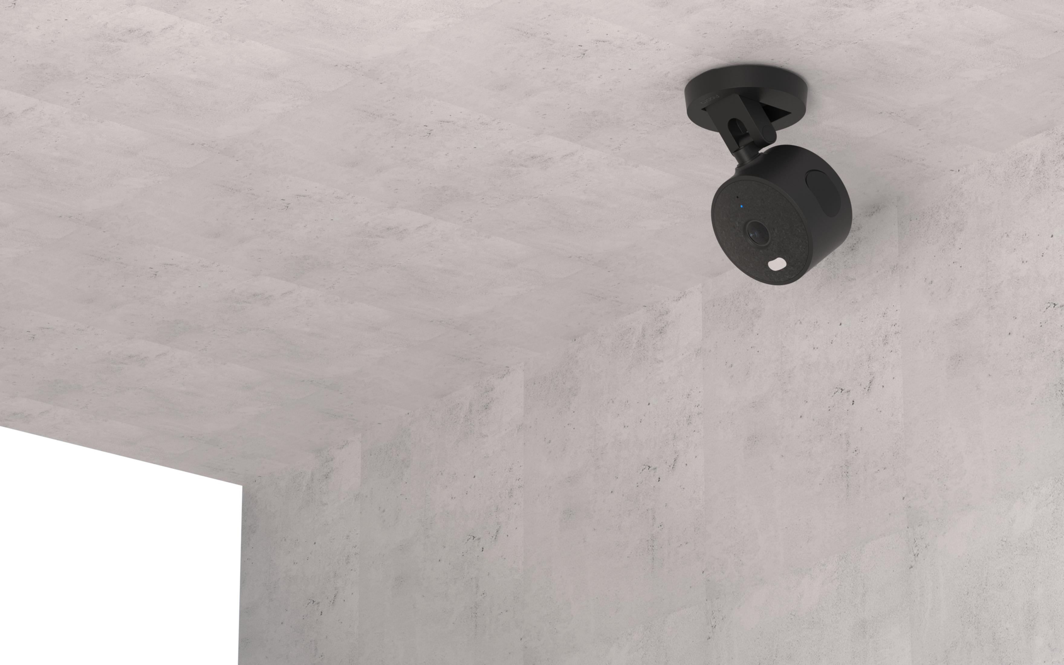 Una telecamera di sicurezza nera è montata su un muro di cemento.
