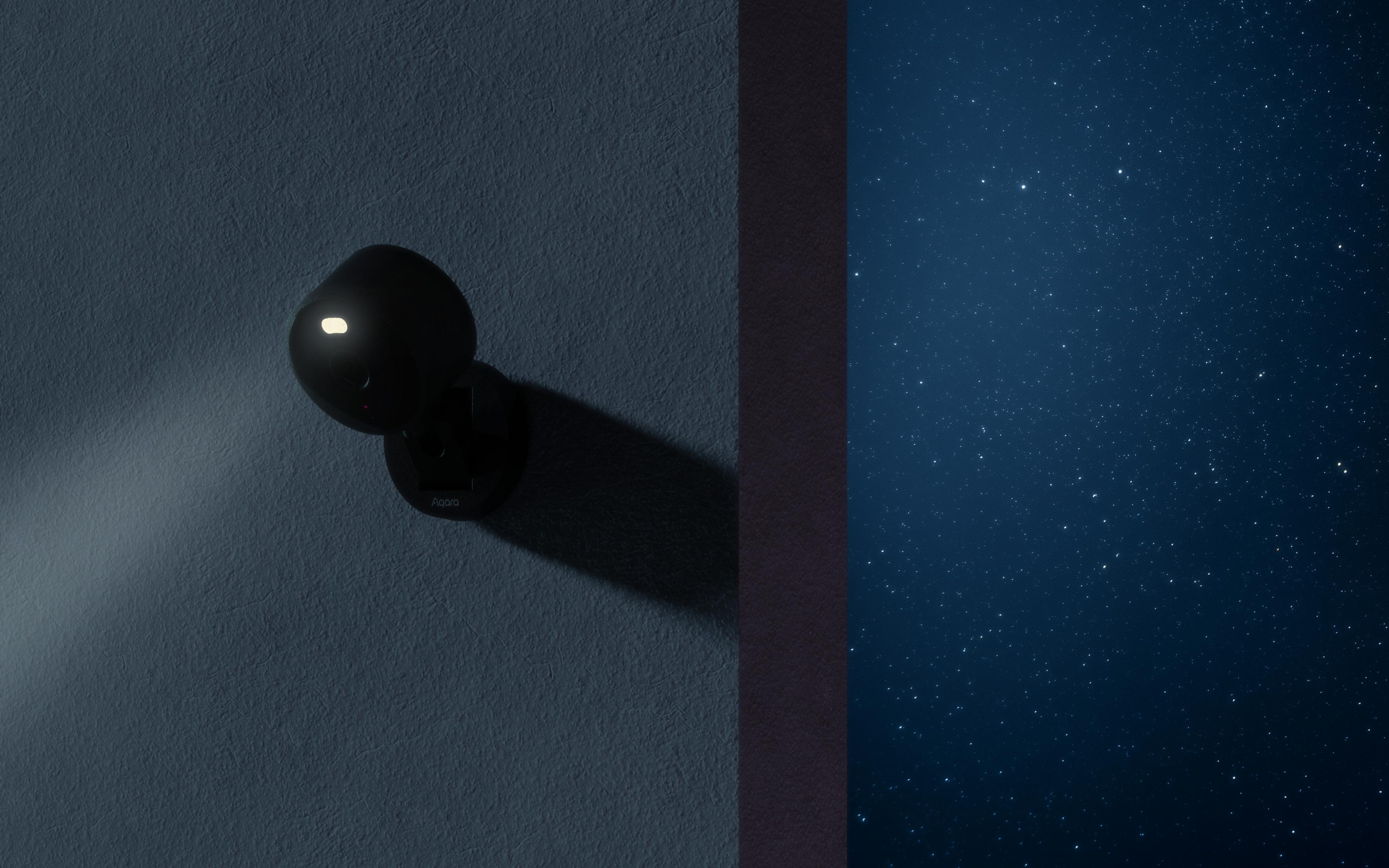 Una telecamera di sicurezza nera con obiettivo illuminato è montata su un muro testurizzato, proiettando un'ombra.