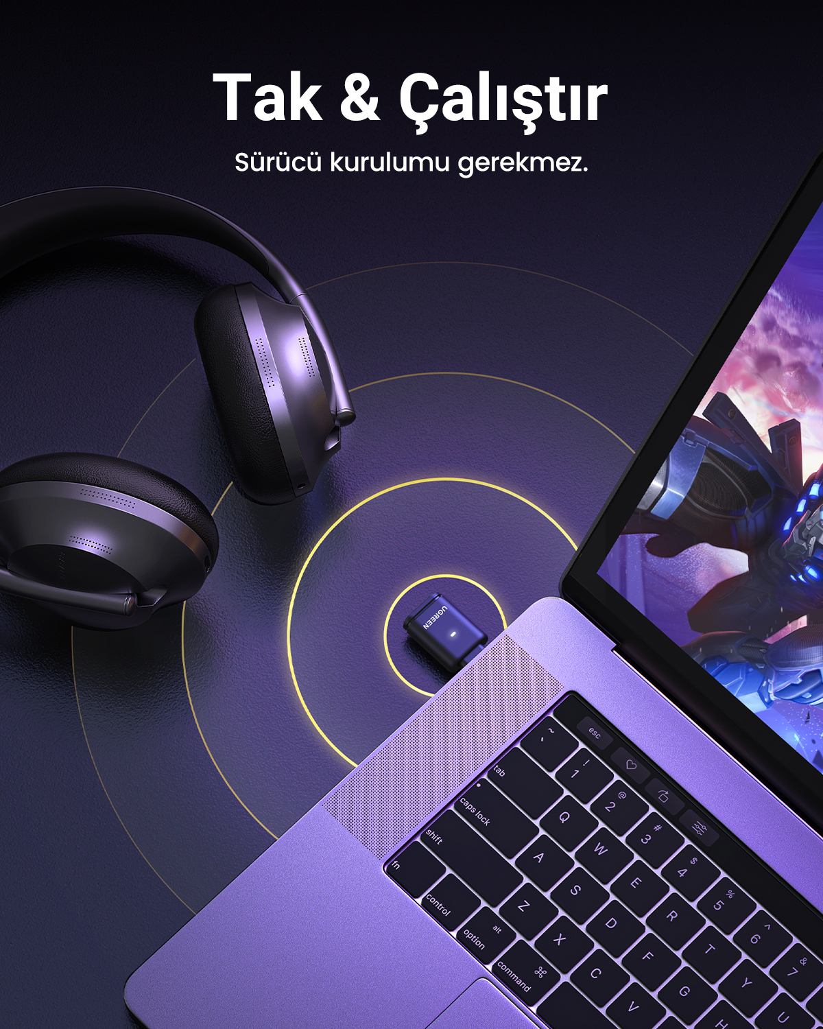 Koyu arka plan üzerinde kulaklık ve küçük USB adaptörlü dizüstü bilgisayar.