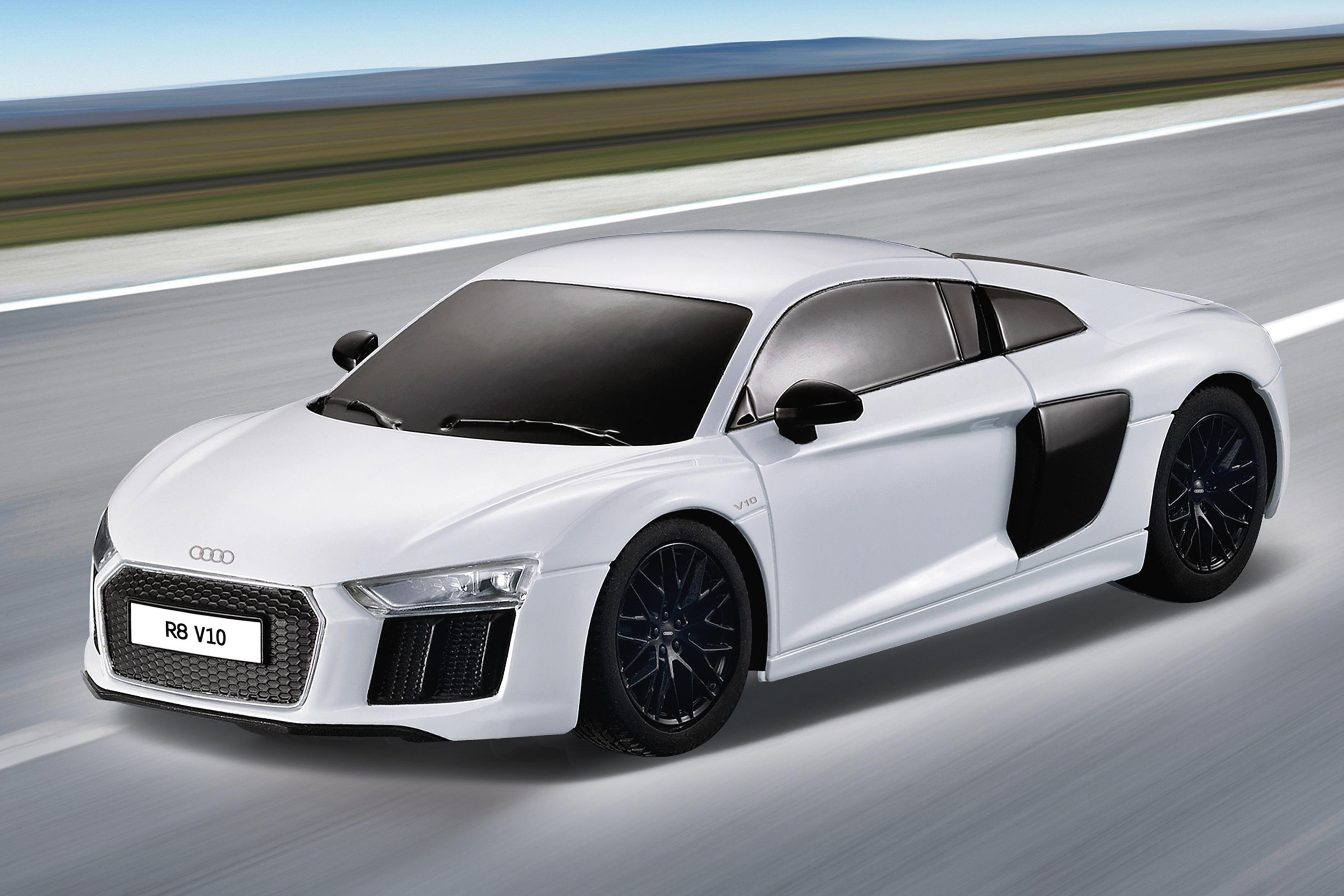 Ein weißer Audi R8 V10 fährt auf einer Straße mit verschwommenem Hintergrund.