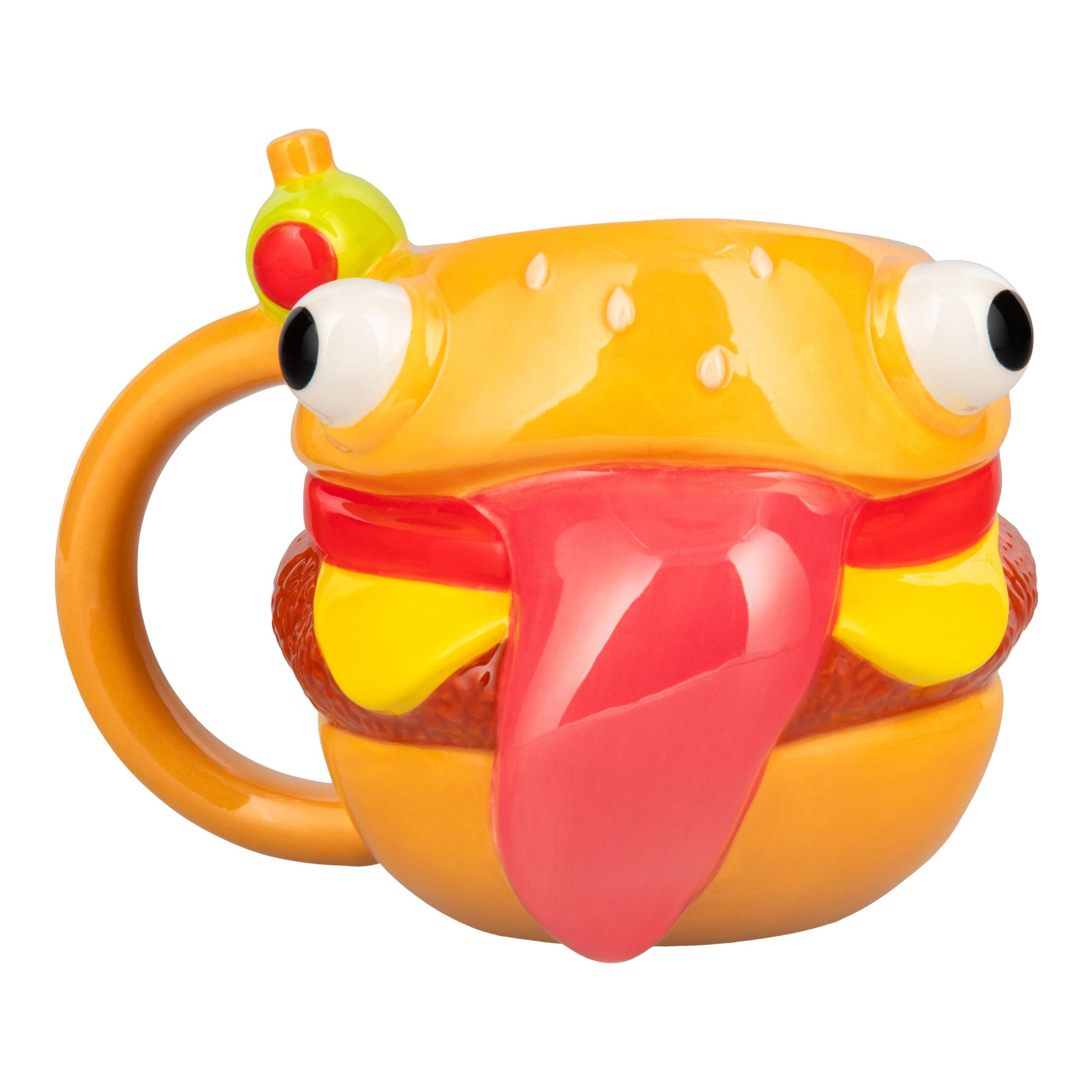 Una taza amarilla con forma de hamburguesa y la lengua fuera.
