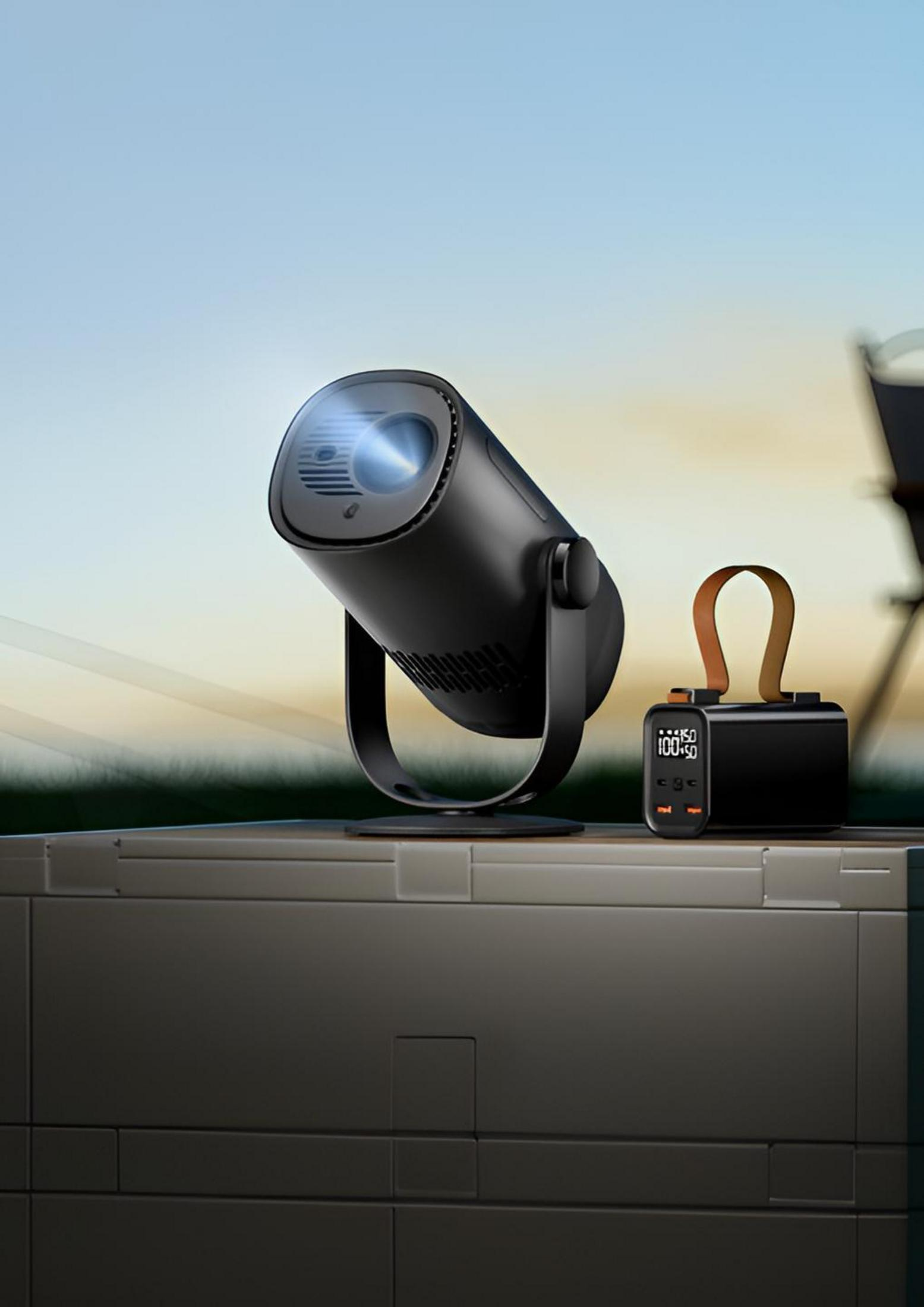 Un proyector negro y un banco de energía sobre una superficie texturizada con fondo de cielo.