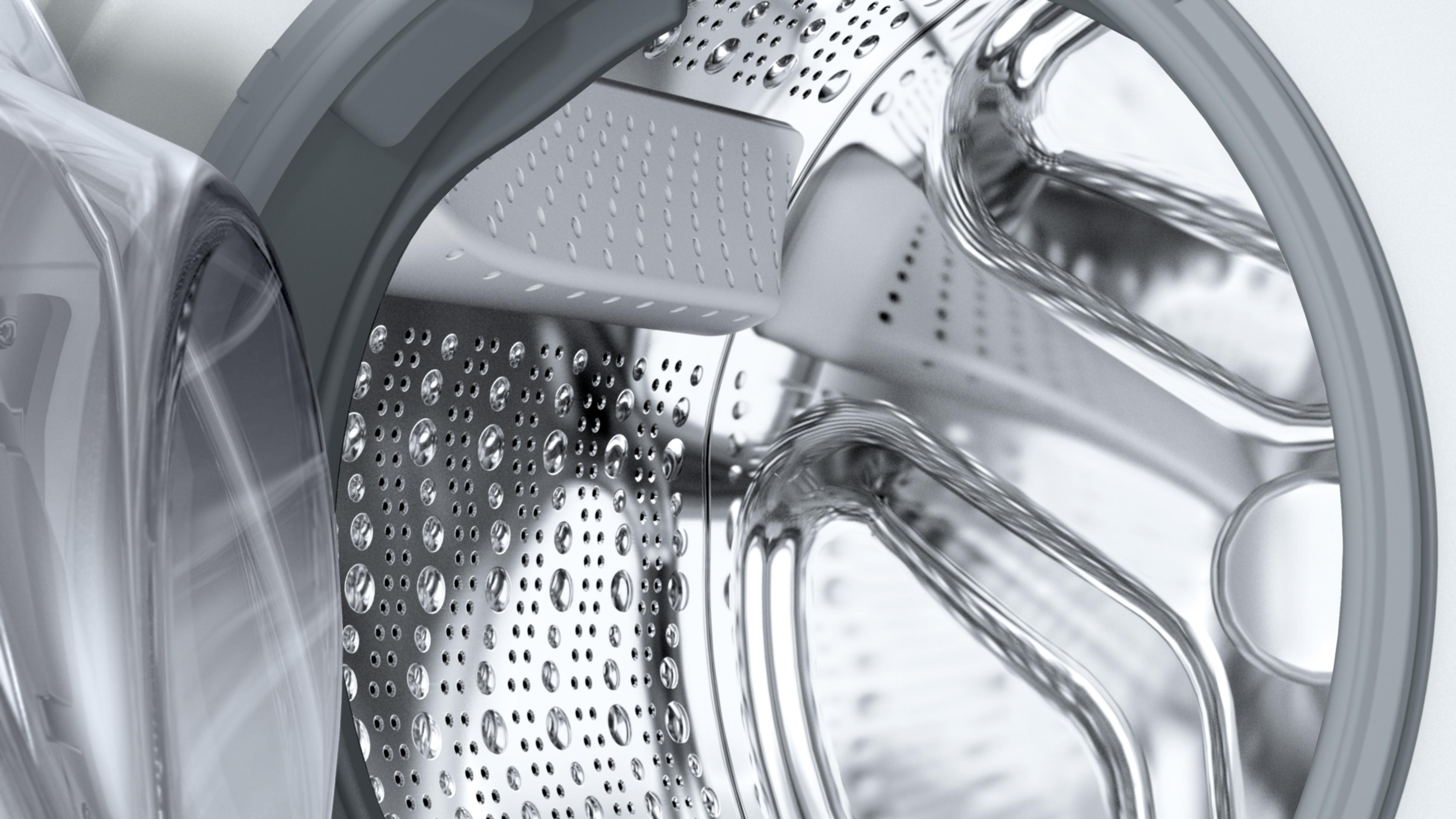 Detailansicht der Trommel einer Waschmaschine mit Wassertropfen und Paddeln.