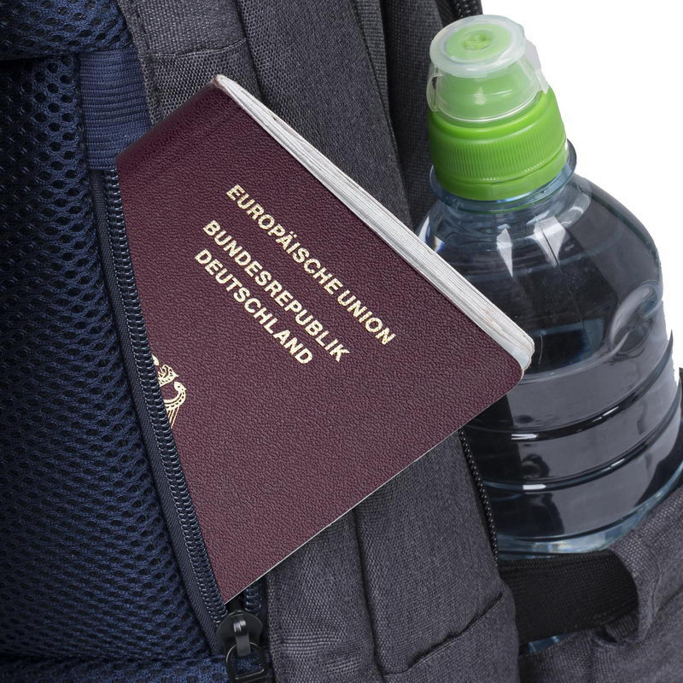 Un passaporto tedesco è nella tasca di uno zaino accanto a una bottiglia d'acqua.