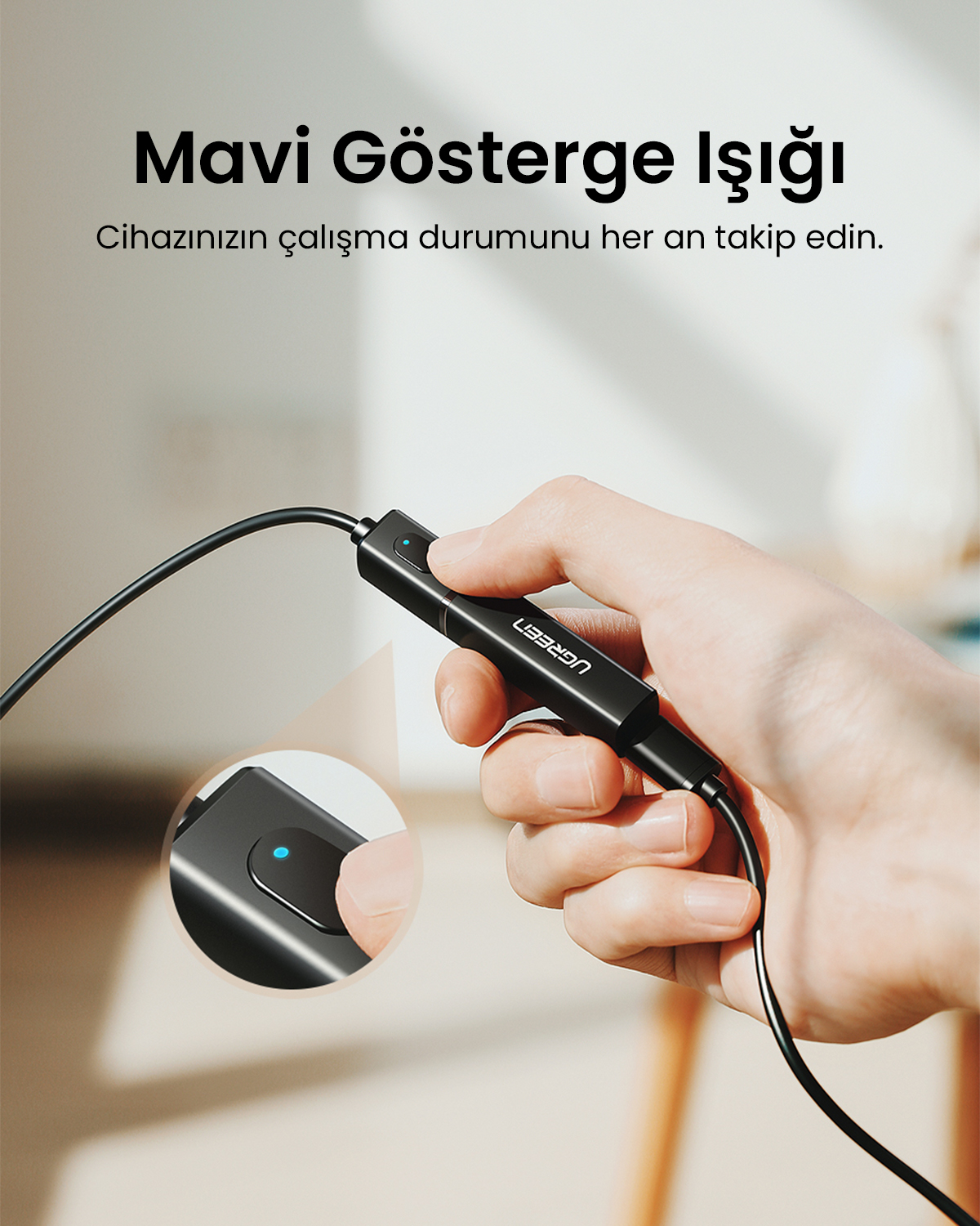 Mavi ışıklı siyah cihazı tutan el, yakın çekim.