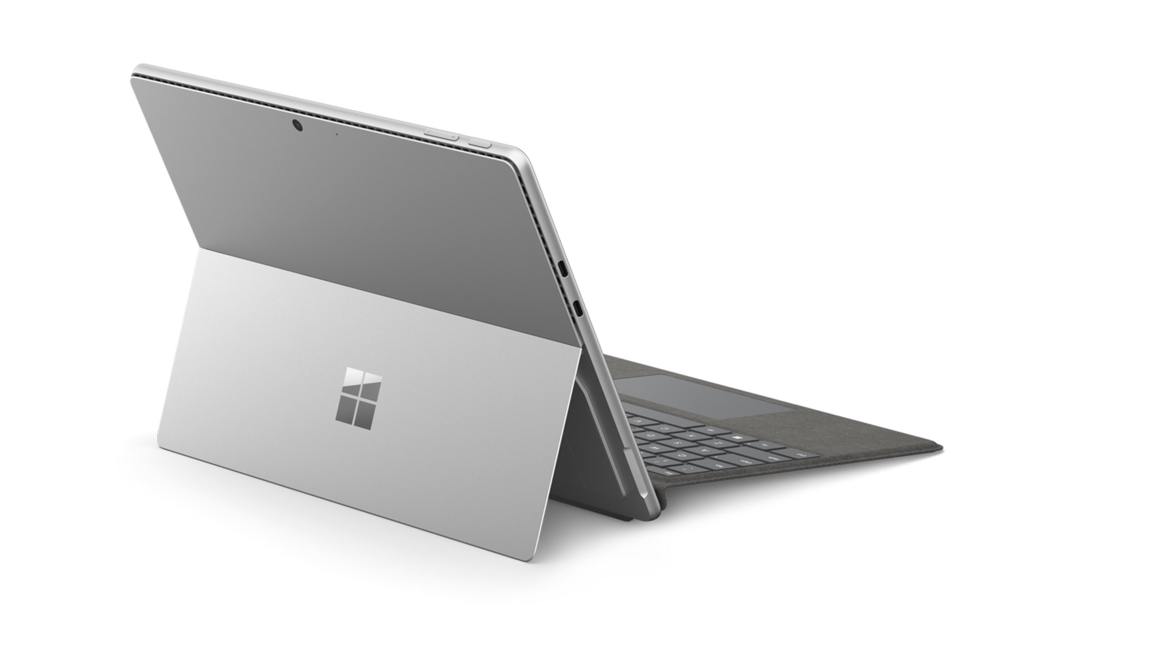 Una tablet Microsoft Surface plateada con su funda teclado acoplada, sobre fondo blanco.