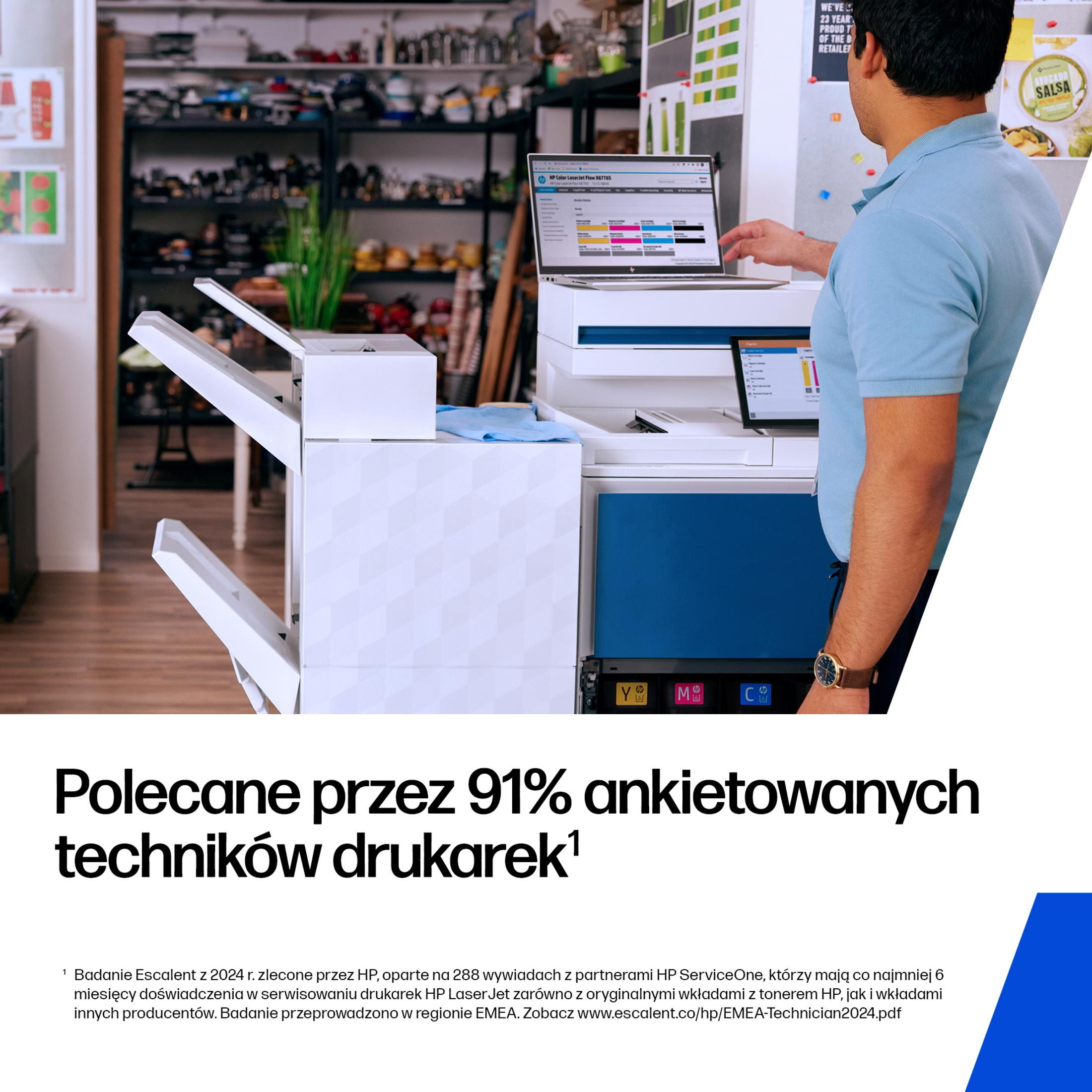 Ein Mann in einem blauen Hemd steht vor einem Drucker und einem Laptop. Regale mit Gegenständen sind im Hintergrund.