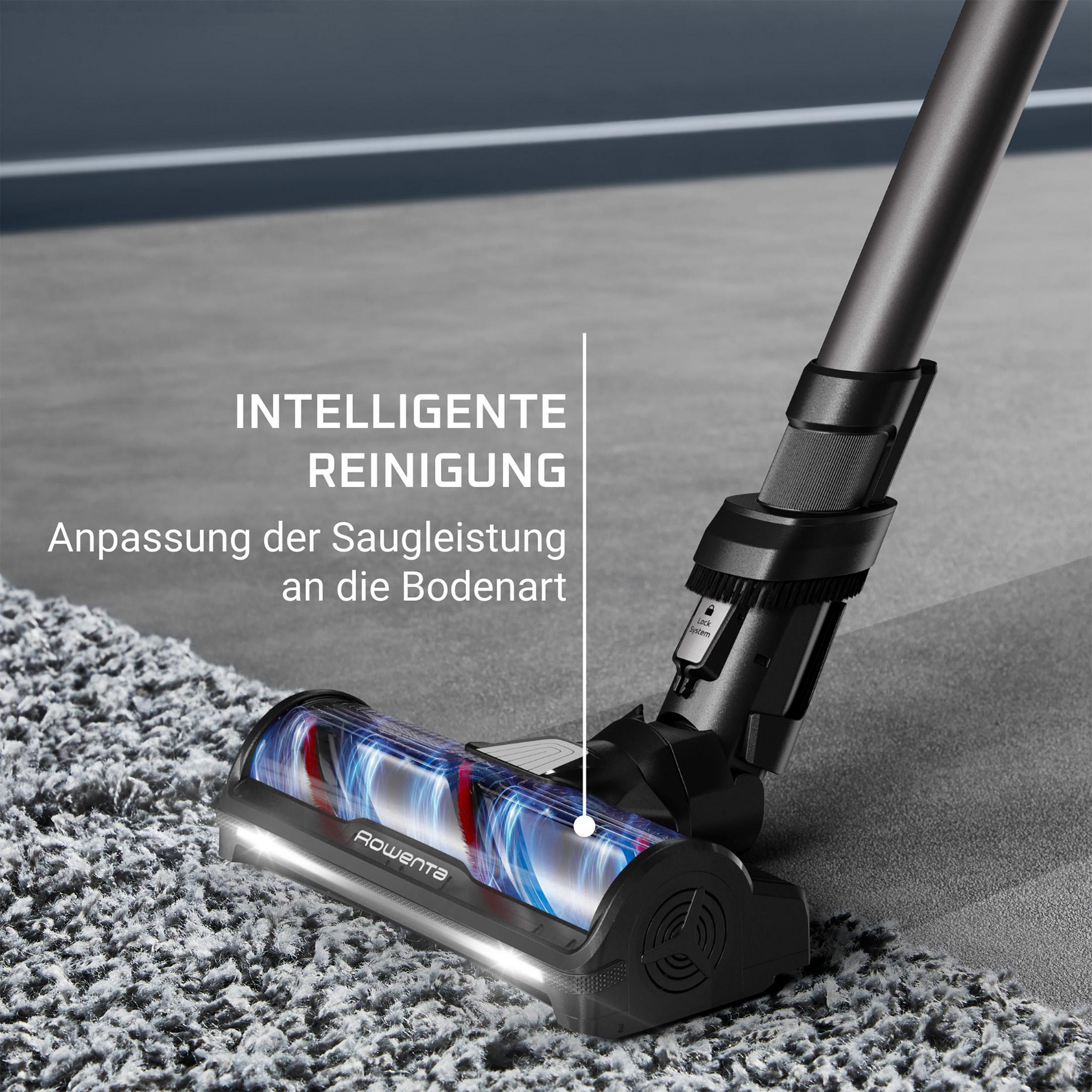 Ein Staubsaugerkopf mit blauem Licht auf einem grauen Teppich.