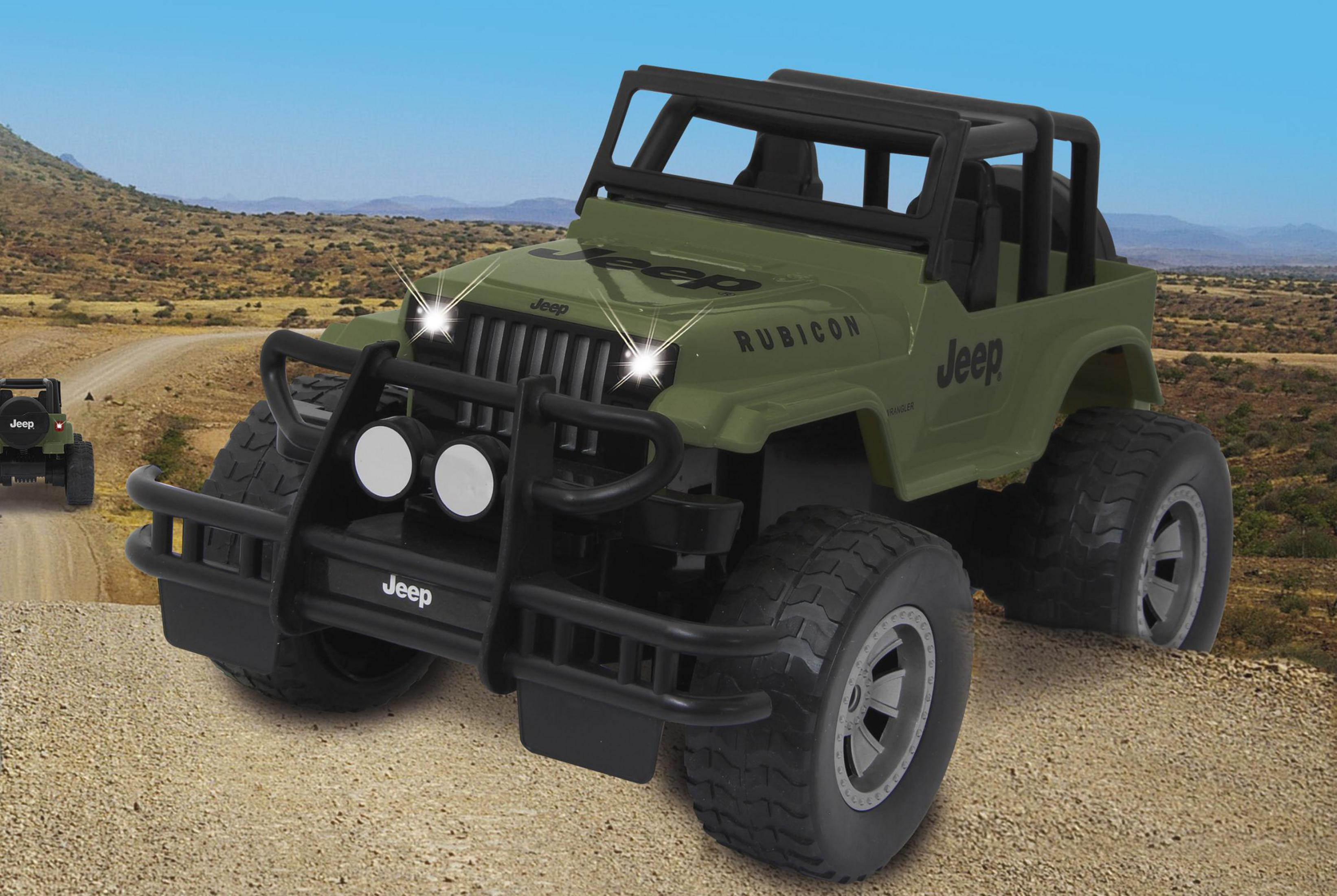 Grüner Spielzeug-Jeep mit großen Reifen auf staubiger Straße.