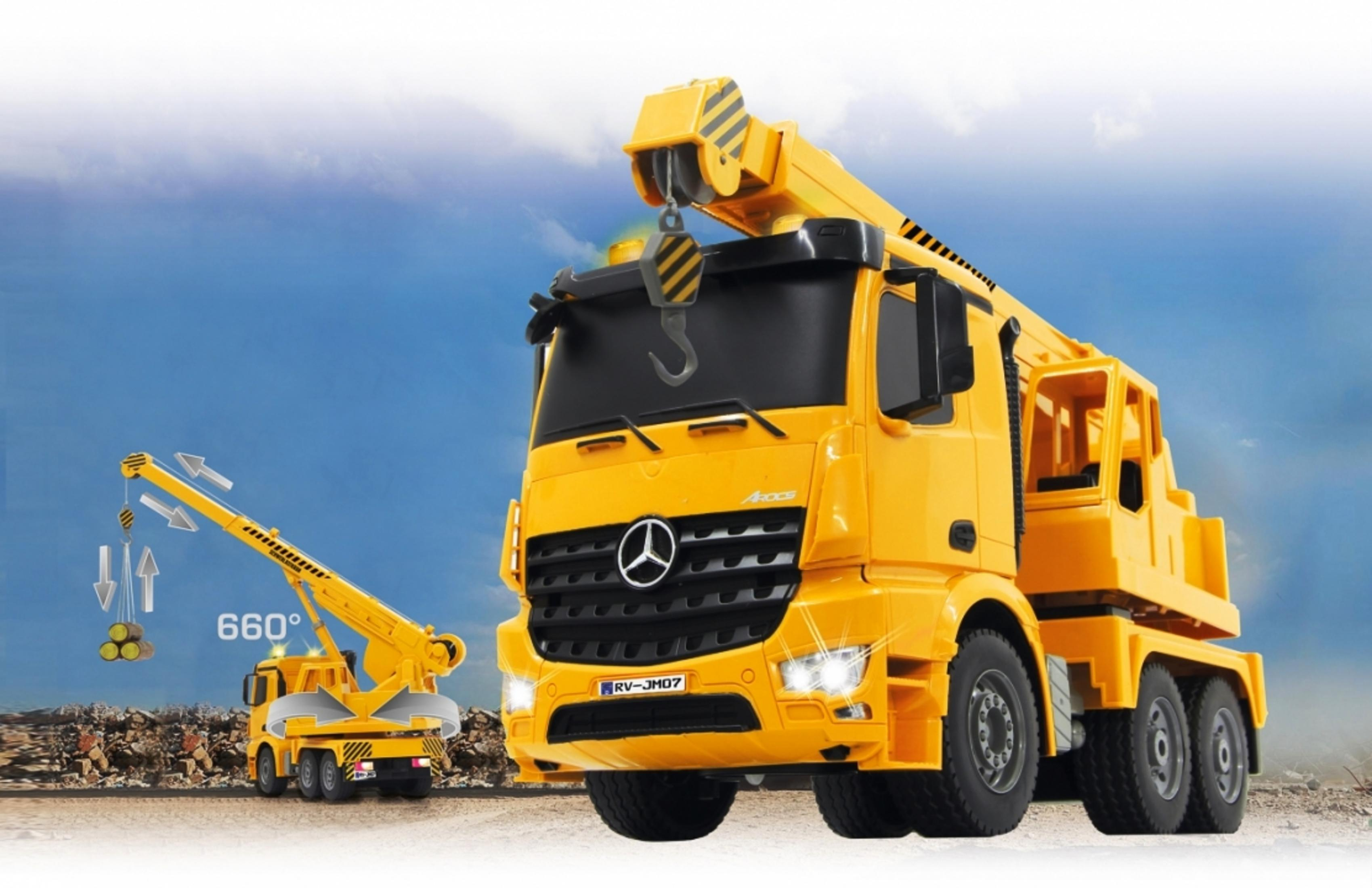 Gelber Kranwagen mit angehobenem Lasten, vor bewölktem Himmel und Schutt.