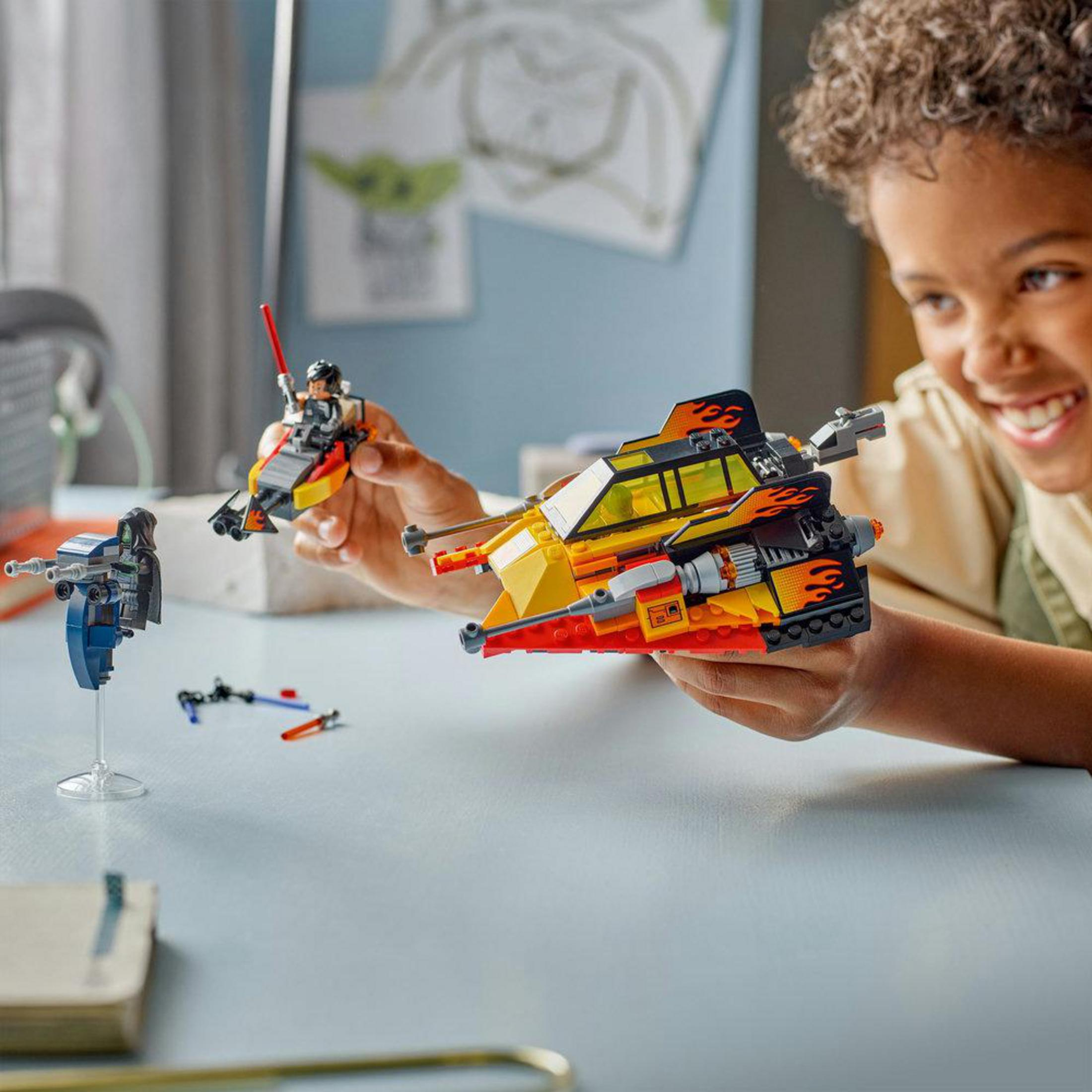 Chłopiec bawi się statkami kosmicznymi i figurkami Lego w pokoju.