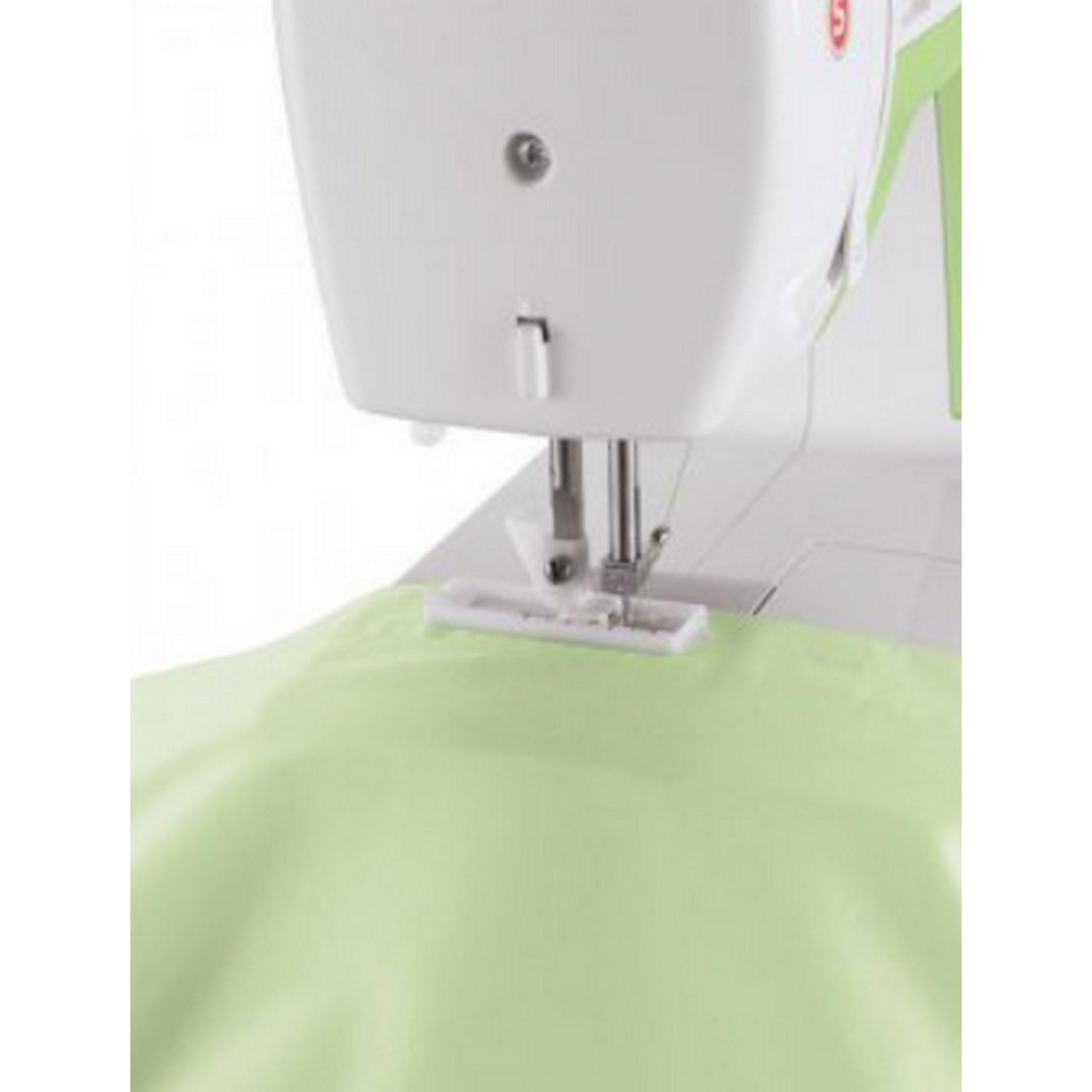 Una macchina da cucire con tessuto verde sotto il piedino.