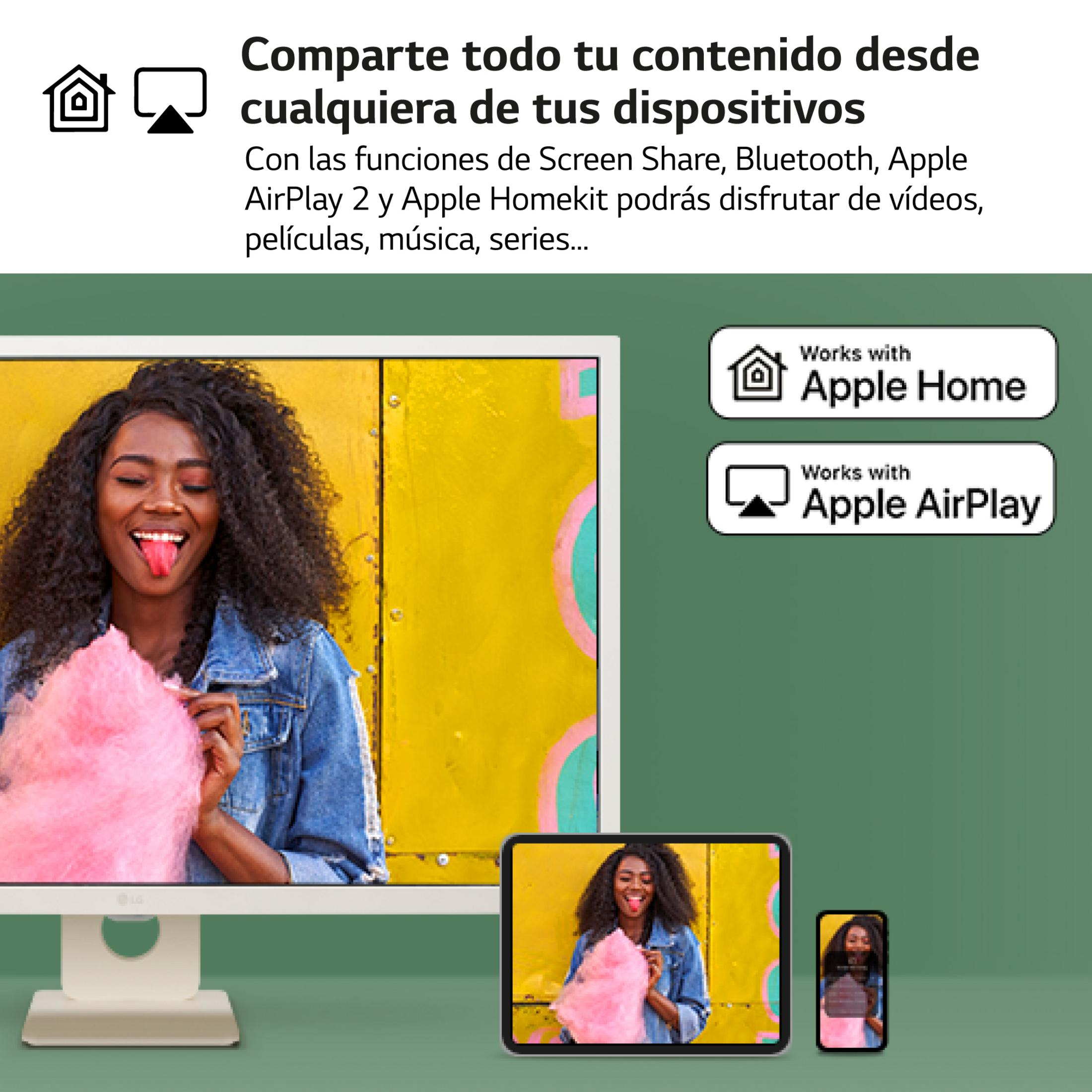 Una donna con capelli ricci mangia zucchero filato rosa davanti a un muro giallo.