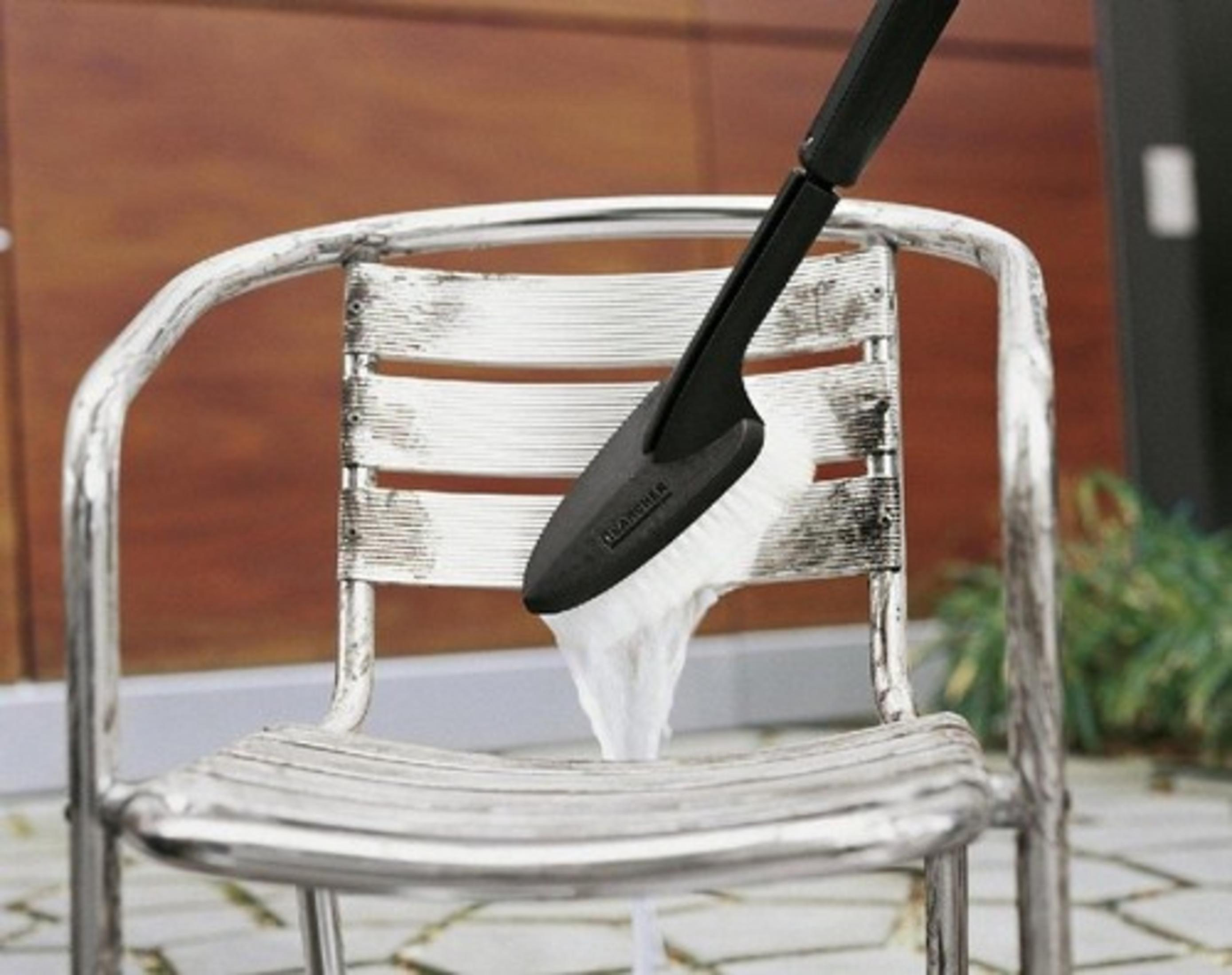 Un cabezal de cepillo limpia una silla sucia con mucha espuma.